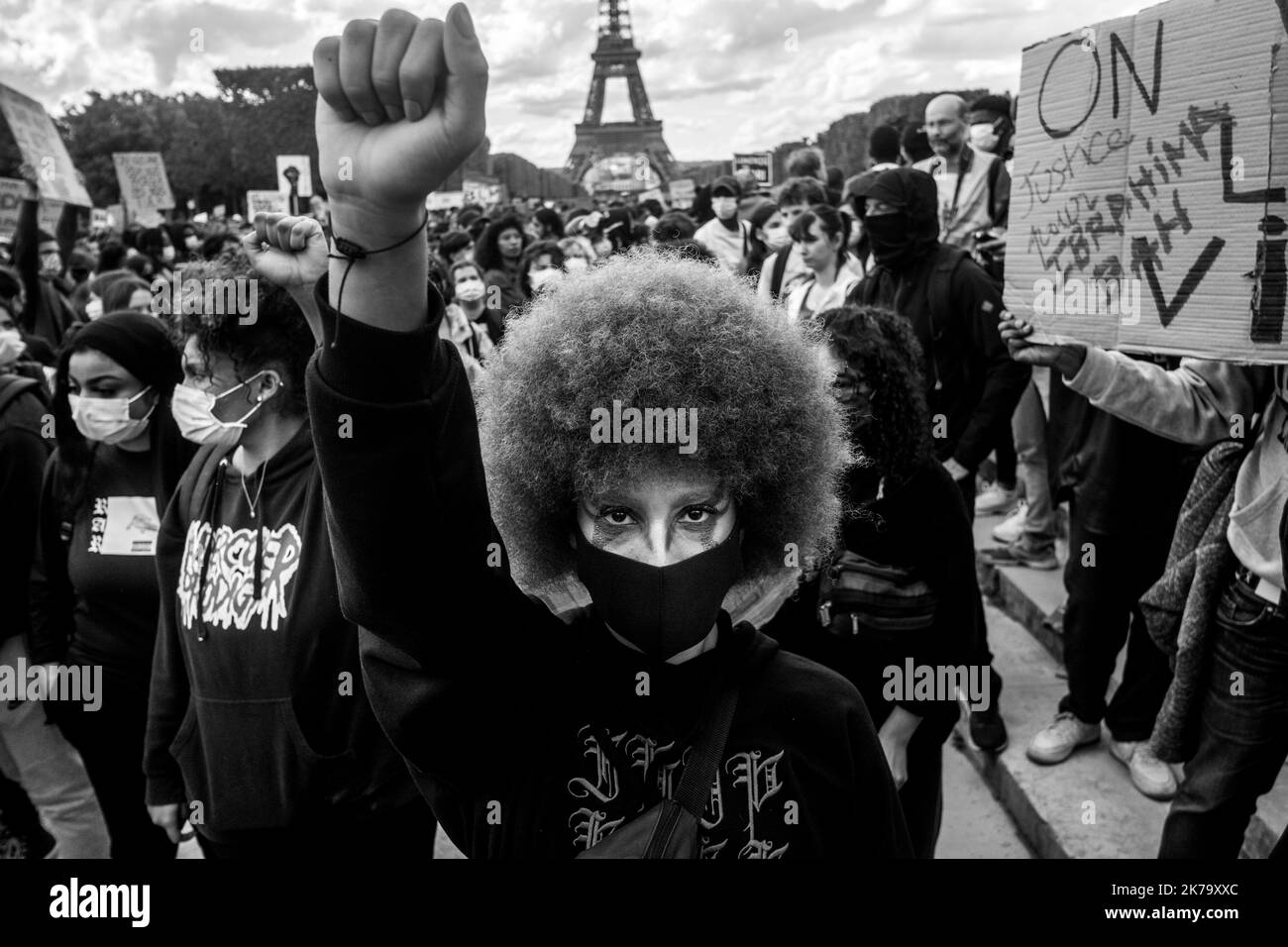 France / Ile-de-France (région) / Paris - les manifestants élèvent leurs poings en l'air et s'agenouillent sur le terrain pour rendre hommage à George Floyd lors d'un rassemblement contre la violence policière et le racisme sur le champ de Mars. George Floyd est mort lors de son arrestation par un policier blanc, Derek Chauvin, 25 mai 2020 à Minneapolis, Minnesota, aux États-Unis. De récentes enquêtes sur le racisme dans la police viennent d'être publiées dans la presse française et trouvent écho à la mort de George Floyd aux États-Unis. Dans de nombreux pays, des manifestations ont lieu en réponse à la mort de George Floyd. Banque D'Images