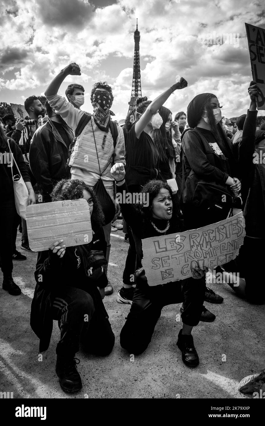 France / Ile-de-France (région) / Paris - les manifestants élèvent leurs poings en l'air et s'agenouillent sur le terrain pour rendre hommage à George Floyd lors d'un rassemblement contre la violence policière et le racisme sur le champ de Mars. George Floyd est mort lors de son arrestation par un policier blanc, Derek Chauvin, 25 mai 2020 à Minneapolis, Minnesota, aux États-Unis. De récentes enquêtes sur le racisme dans la police viennent d'être publiées dans la presse française et trouvent écho à la mort de George Floyd aux États-Unis. Dans de nombreux pays, des manifestations ont lieu en réponse à la mort de George Floyd. Banque D'Images
