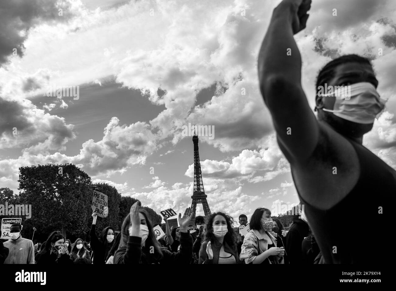 France / Ile-de-France (région) / Paris - les manifestants élèvent leurs poings en l'air et s'agenouillent sur le terrain pour rendre hommage à George Floyd lors d'un rassemblement contre la violence policière et le racisme sur le champ de Mars. George Floyd est mort lors de son arrestation par un policier blanc, Derek Chauvin, 25 mai 2020 à Minneapolis, Minnesota, aux États-Unis. De récentes enquêtes sur le racisme dans la police viennent d'être publiées dans la presse française et trouvent écho à la mort de George Floyd aux États-Unis. Dans de nombreux pays, des manifestations ont lieu en réponse à la mort de George Floyd. Banque D'Images
