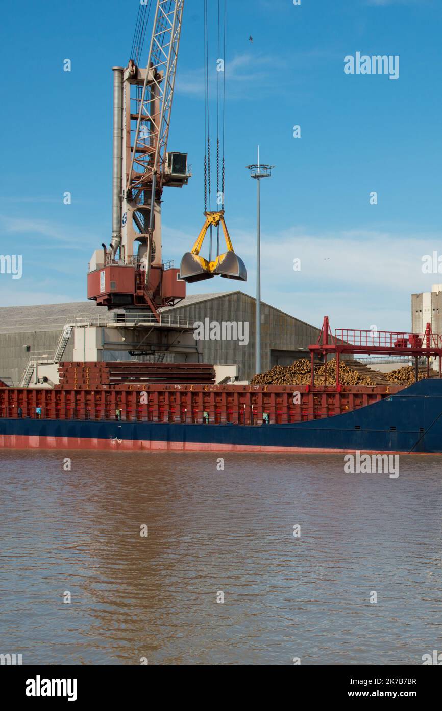 Bordeaux, France; 08092022: Grue de port chargeant un navire avec du bois. Banque D'Images