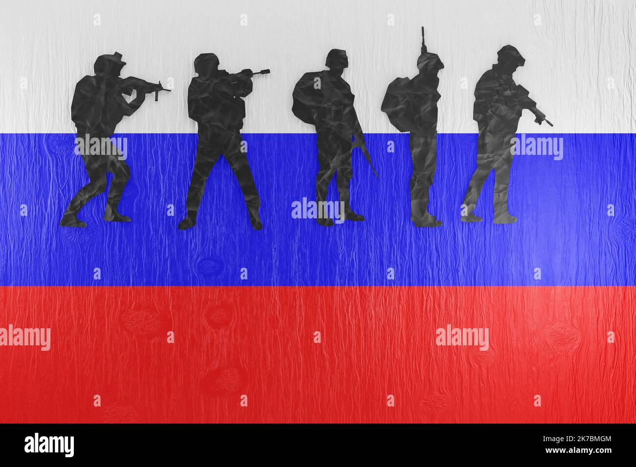 Découpe de papier de silhouettes de solders sur une table en bois imprimée avec le drapeau national de la Russie. Actions militaires et conscription russes Banque D'Images