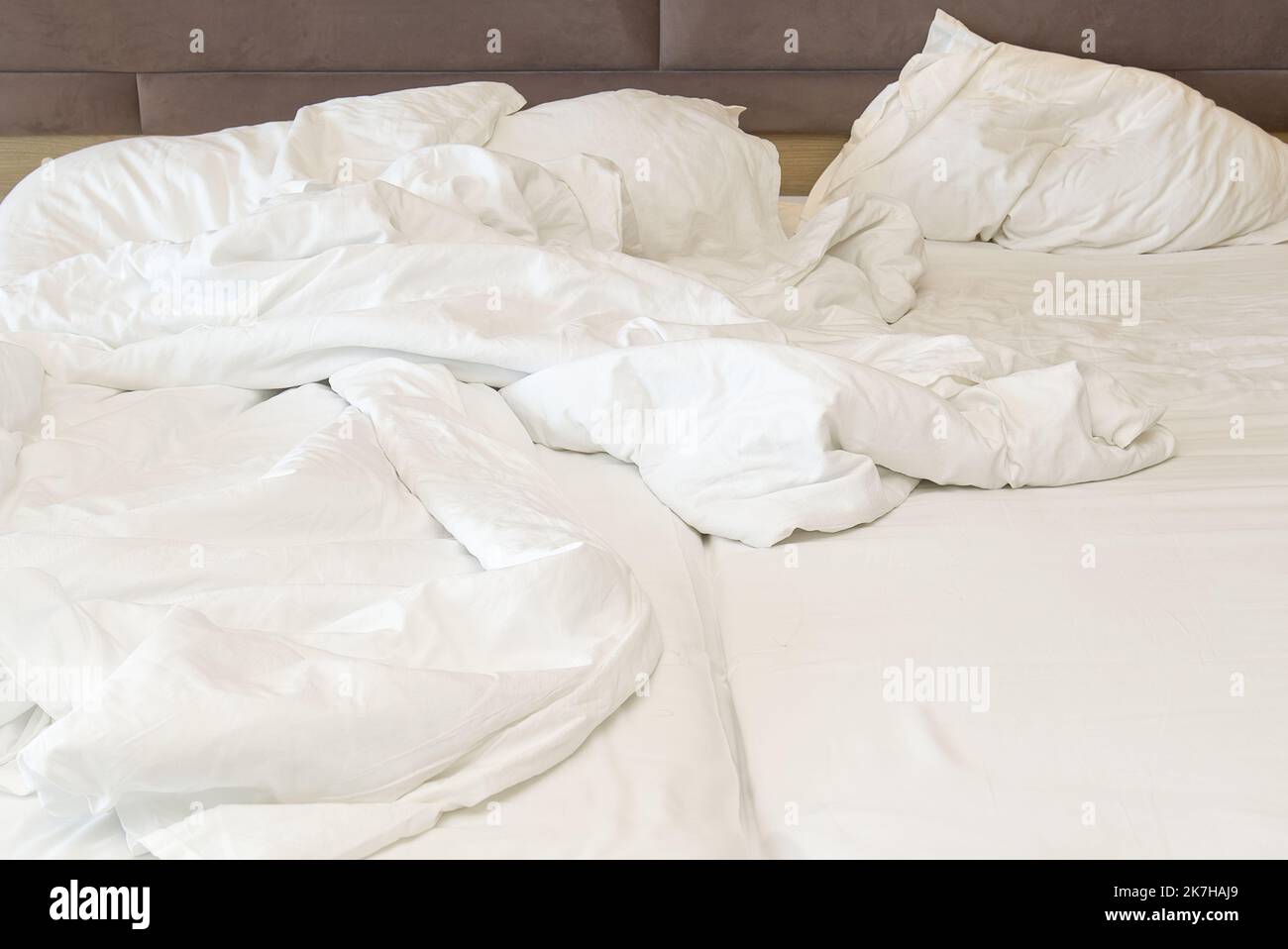 lit froissé après une nuit d'amour pleine de tempête. Gros plan sur une couverture blanche et moelleuse dans la chambre Banque D'Images