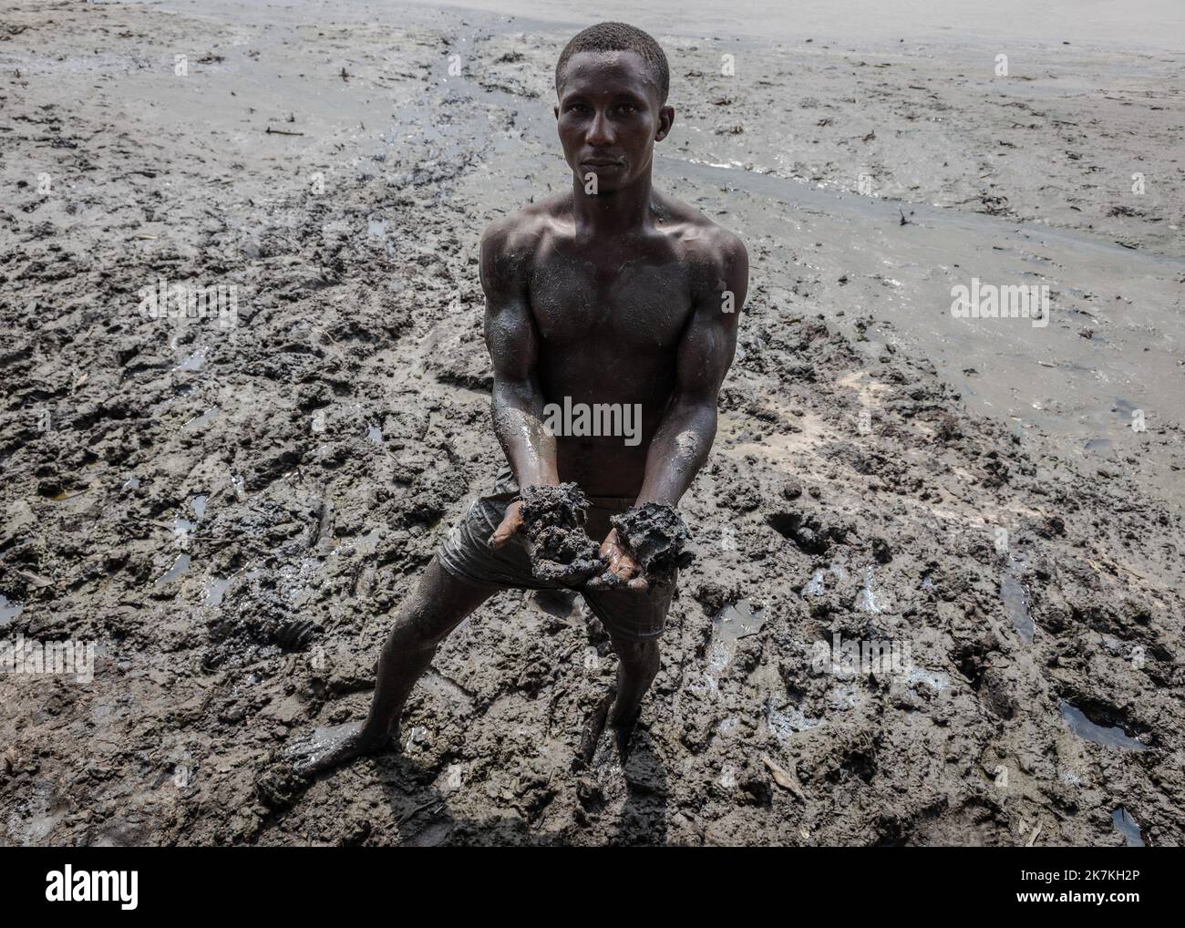 ©Sadak Souici / le Pictorium/MAXPPP - 22/01/2022 Sadak Souici / le Pictorium - 22/1/2022 - Nigeria - « cette boue empeste le petrole, les coquillages et les crabes que nous consommons aussi » explication Tanen Nwinelgior, un pecheur de 27 ans. Dans le Delta du Niger, d'or jaillissent quotidiennement pres de 2% de la production mondiale d'hydrocarbures, les serres noires se multiplent et ruinent d'intombrbles communautaires de pêcheurs et d'agriculteurs. Si certains sont assignés en justice les majors petrolieres responsables du desastre, les indemnités et le nettoyage n'ont pas permis de retalule Banque D'Images