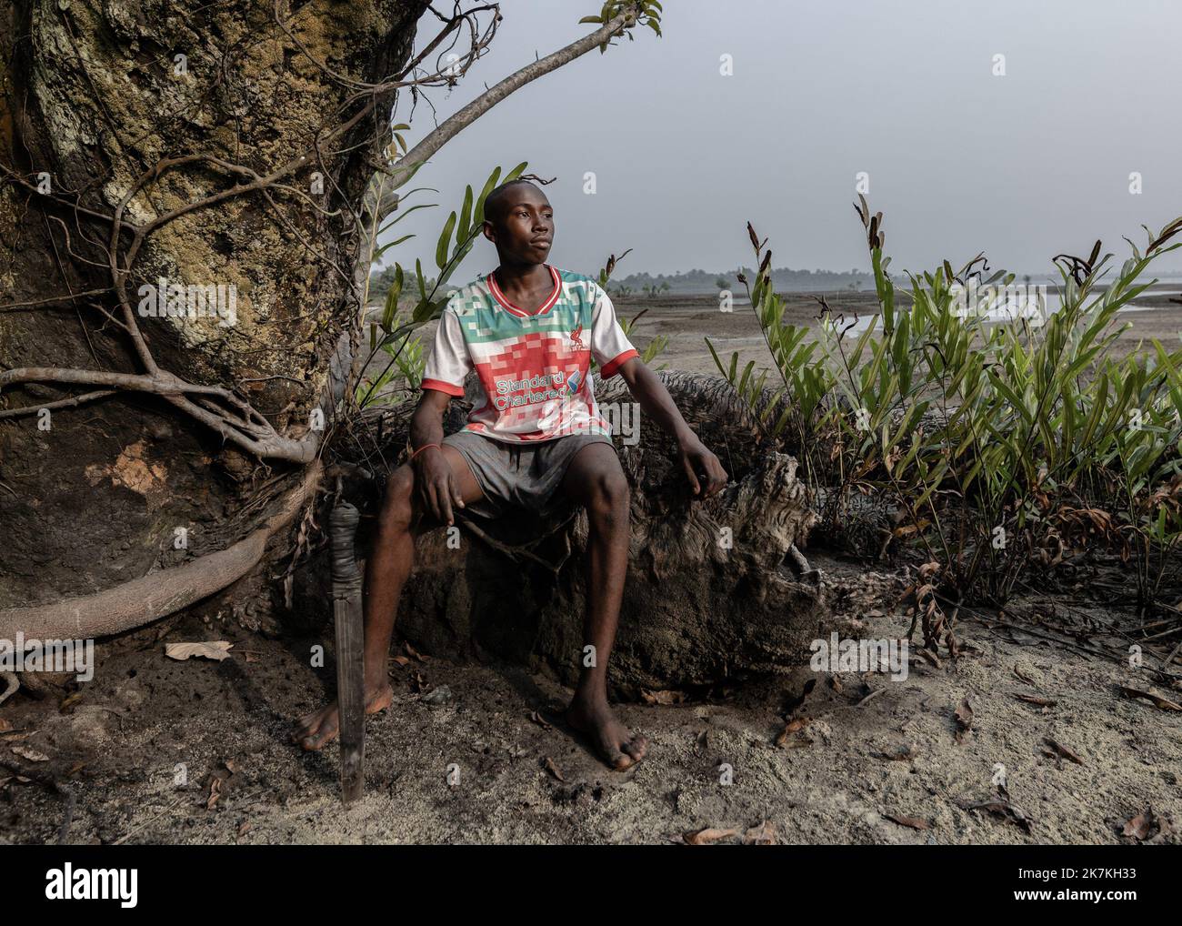 ©Sadak Souici / le Pictorium/MAXPPP - 21/01/2022 Sadak Souici / le Pictorium - 21/1/2022 - Nigeria - « J'aime faire ma vie ici, mais il est possible que je dois migrer vers Lagos » s'inquiete Victor, 14 ans, qui tente de repousser la mangrove dans un vase d'hydrobuteur. Dans le Delta du Niger, d'or jaillissent quotidiennement pres de 2% de la production mondiale d'hydrocarbures, les serres noires se multiplent et ruinent d'intombrbles communautaires de pêcheurs et d'agriculteurs. Si certains ont affecté en justice les majors petrolieres responsables du desastre, les indemni Banque D'Images