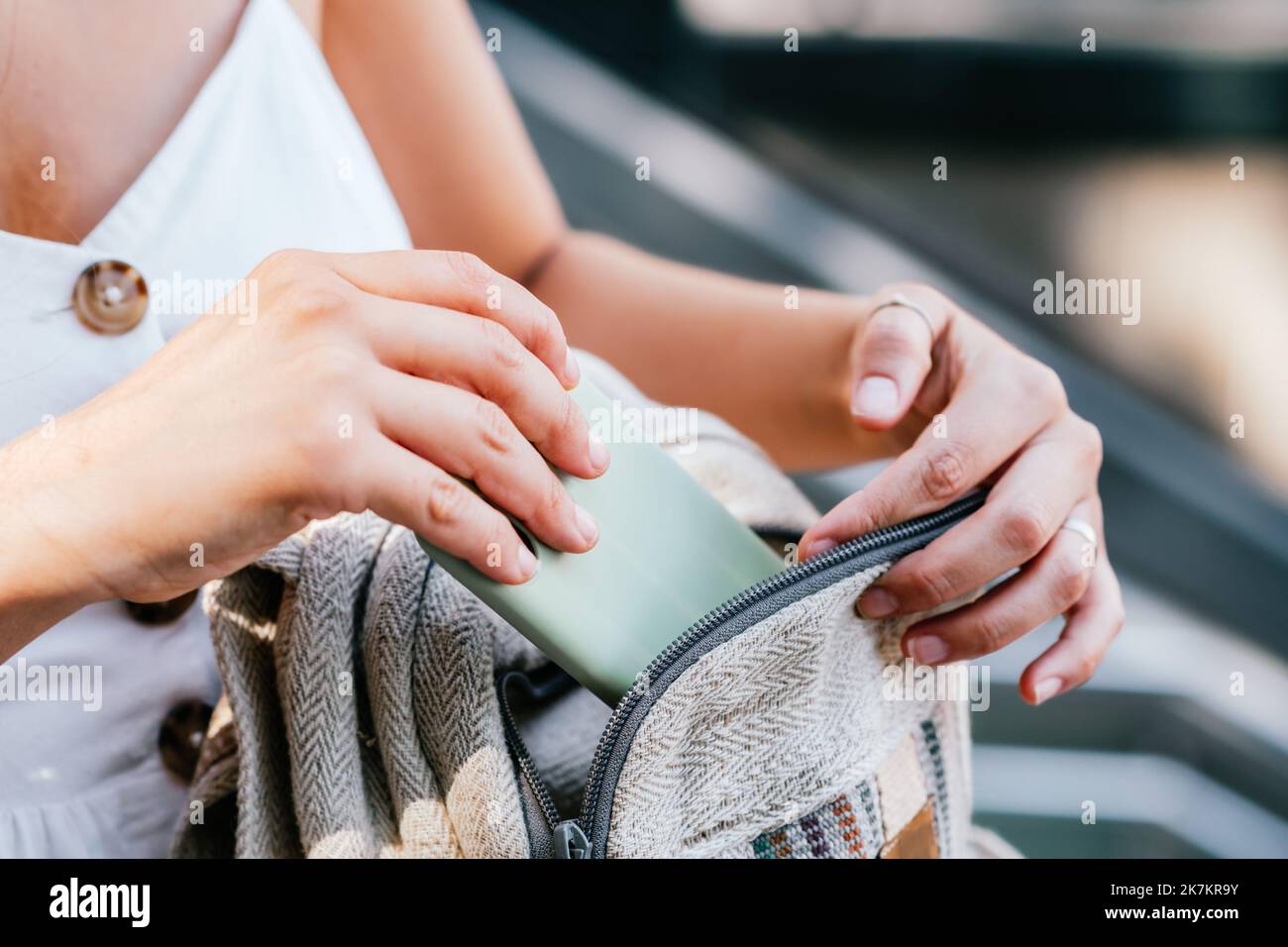 D'en haut anonyme femelle prenant le téléphone portable de sac à dos le jour ensoleillé dans la rue à Barcelone, Espagne Banque D'Images
