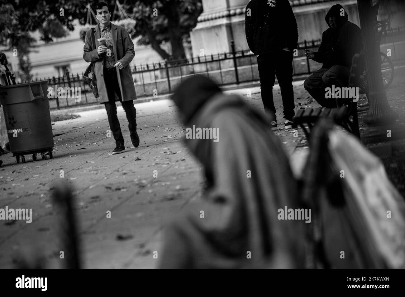 Pendant les heures de pointe du matin, les gens passent devant les sans-abri de la place McPherson à Washington, DC, lundi, 17 octobre 2022. Il y a environ trois douzaines de tentes dans le parc, avec une buanderie accrochée sur des branches d'arbres, des chaises, des tables et même deux salles de bains portatives. Il s'agit de l'une des nombreuses communautés sans abri, y compris les vétérans américains, dans la capitale de nations, dans des lieux de haute visibilité publique, coexistant avec les résidents locaux. Crédit : Rod Lamkey/CNP Banque D'Images