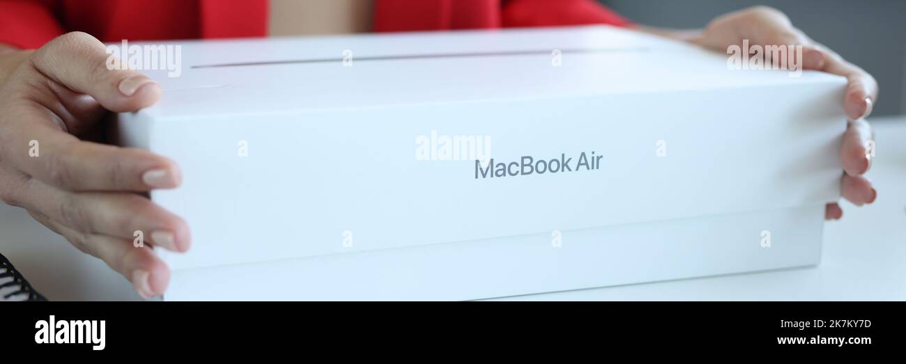 Femme tient le nouvel ordinateur portable Apple MacBook Pro dans son emballage Banque D'Images