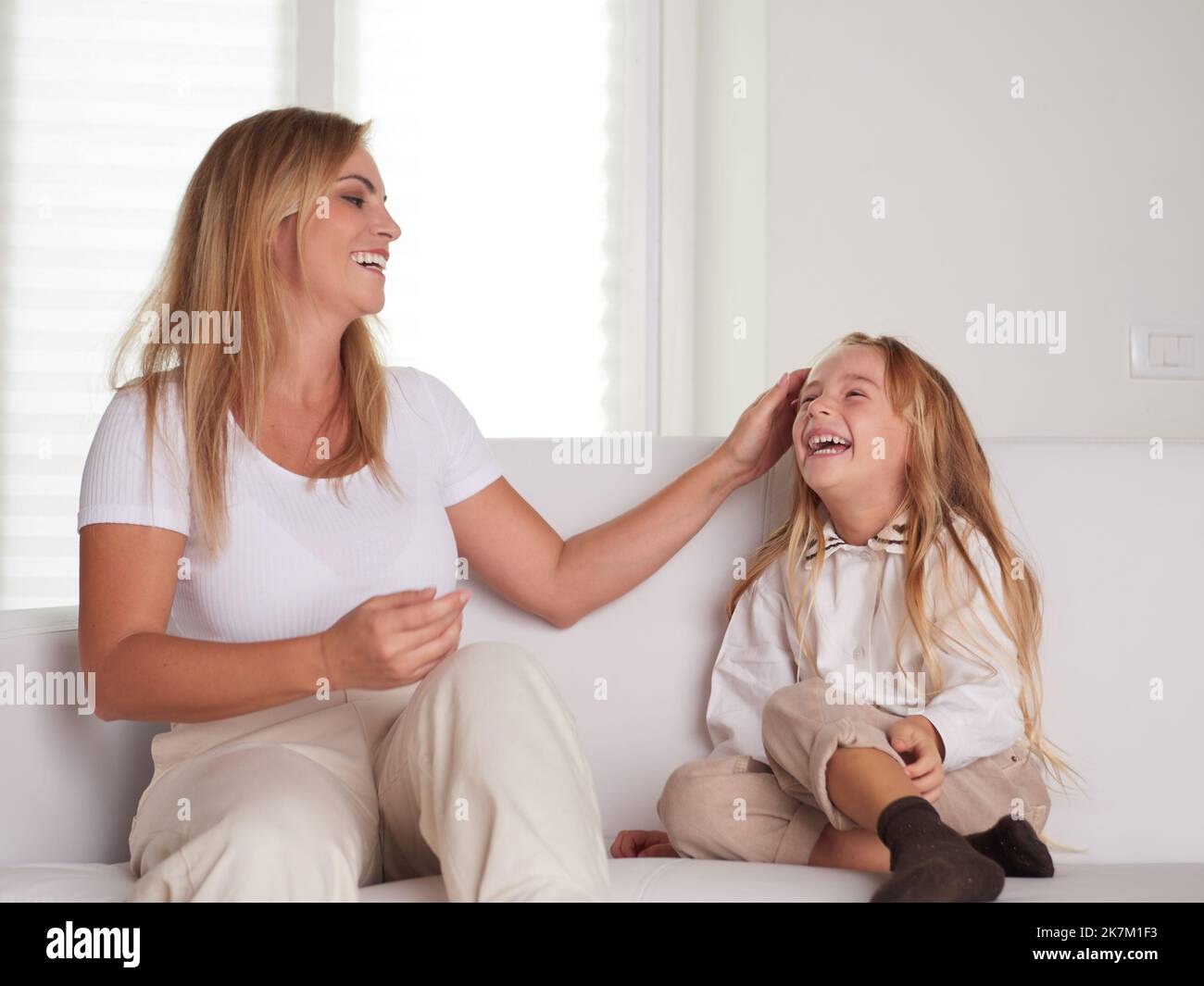 Jeune belle mère jouant avec sa fille dans le salon Banque D'Images