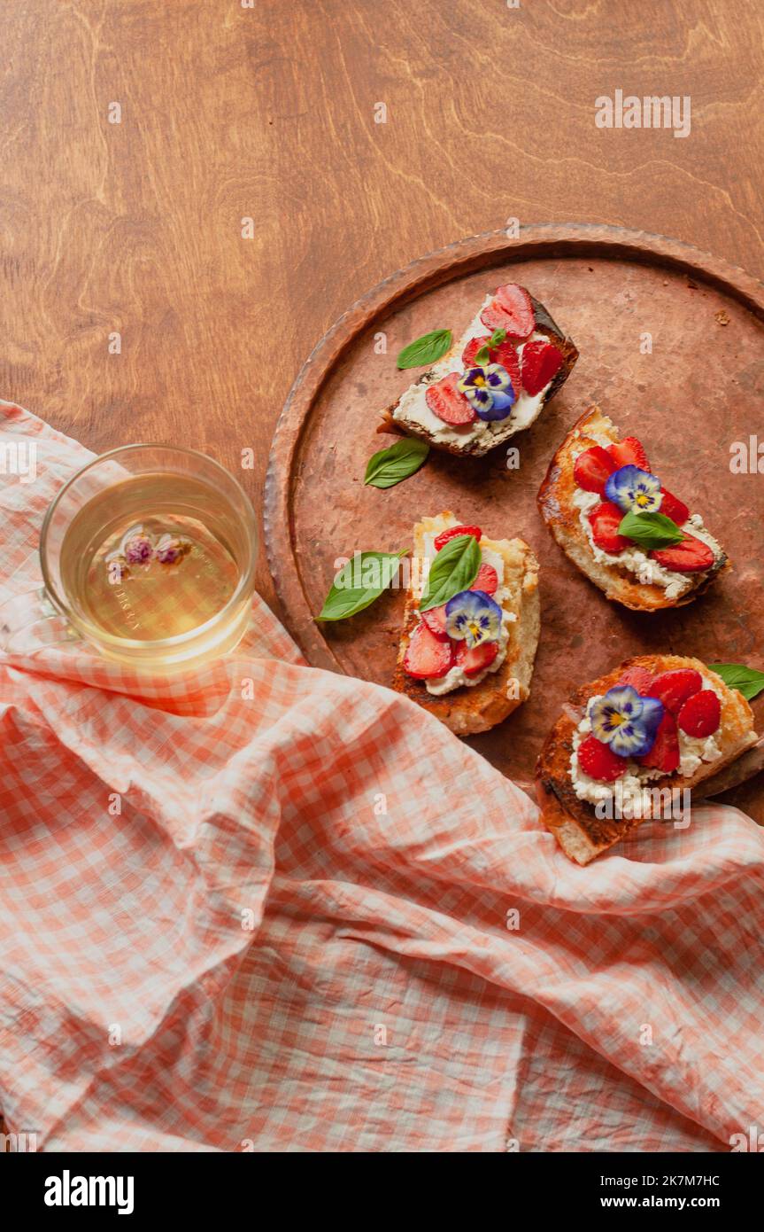 Pain doré aux fraises, brioche au fromage à la crème, fleurs et basilic plat Banque D'Images