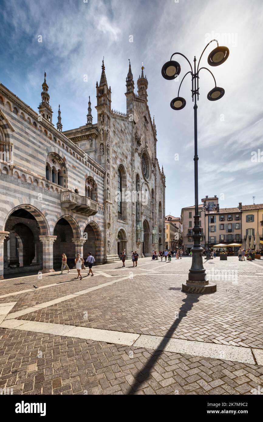 Façade principale de la cathédrale de style gothique par temps ensoleillé. Personnes traversant la Piazza del Duomo en face. Image à plage dynamique élevée. Banque D'Images