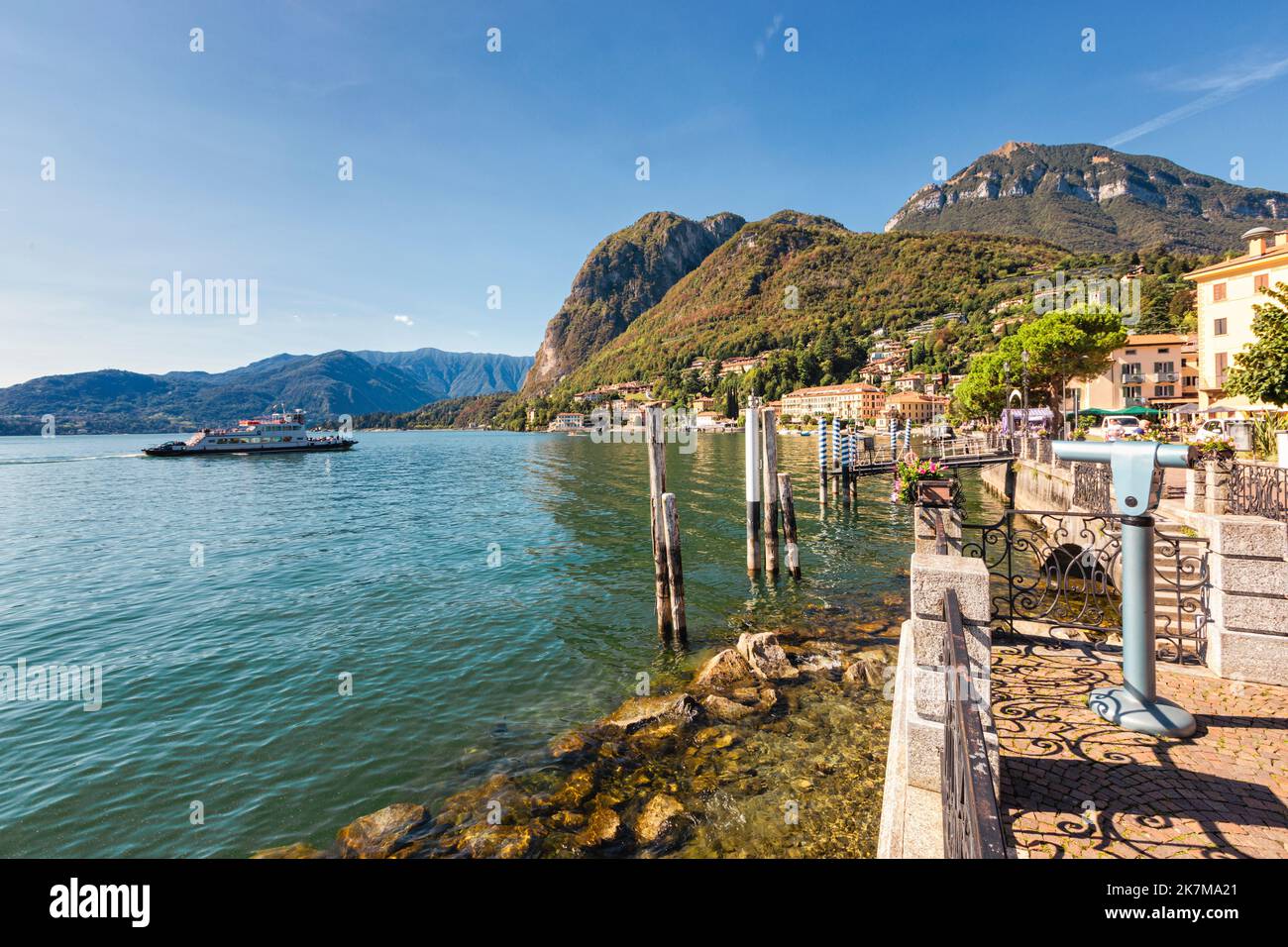 Vue panoramique depuis la promenade de Menaggio sur le lac de l'ouest du lac de Côme, Lombardie, Italie. Jour ensoleillé, un ferry approchant de la jetée. Banque D'Images Vue panoramique depuis la promenade de Menaggio sur le lac de l'ouest du lac de Côme, Lombardie, Italie. Jour ensoleillé, un ferry approchant de la jetée. Banque D'Images