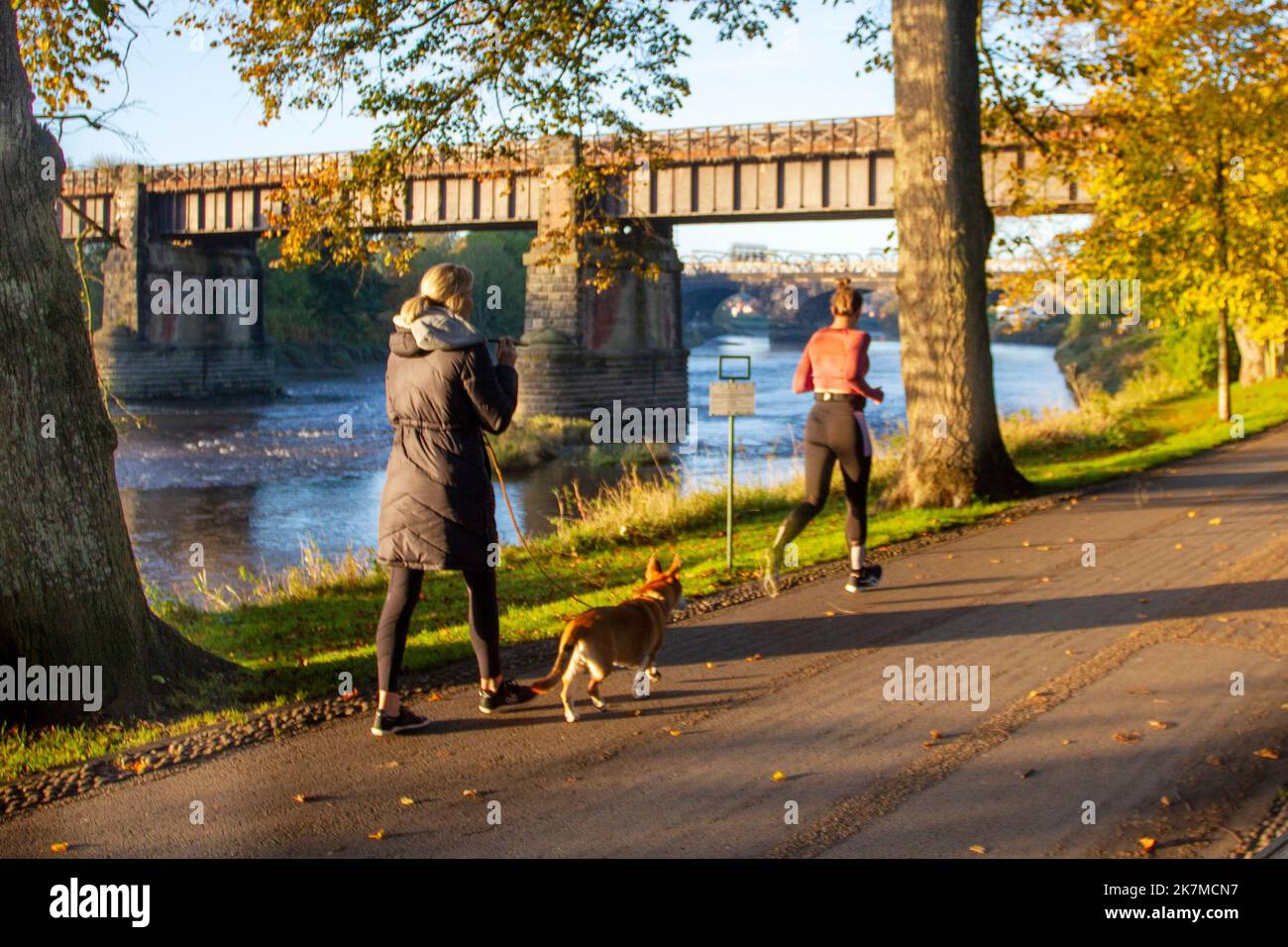 Preston, Lancashire. Météo au Royaume-Uni ; 18 octobre 2022. Le soleil se lève au-dessus de la rivière Ribble tandis que les habitants de la région font de l'exercice léger à l'aube le long de Riverside Walk, un froid brumeux point de départ de la journée. Avenham Park Family Space, pistes cyclables et sentiers de randonnée dans le nord-ouest de l'Angleterre. Crédit; MediaWorldImages/AlamyLiveNews Banque D'Images