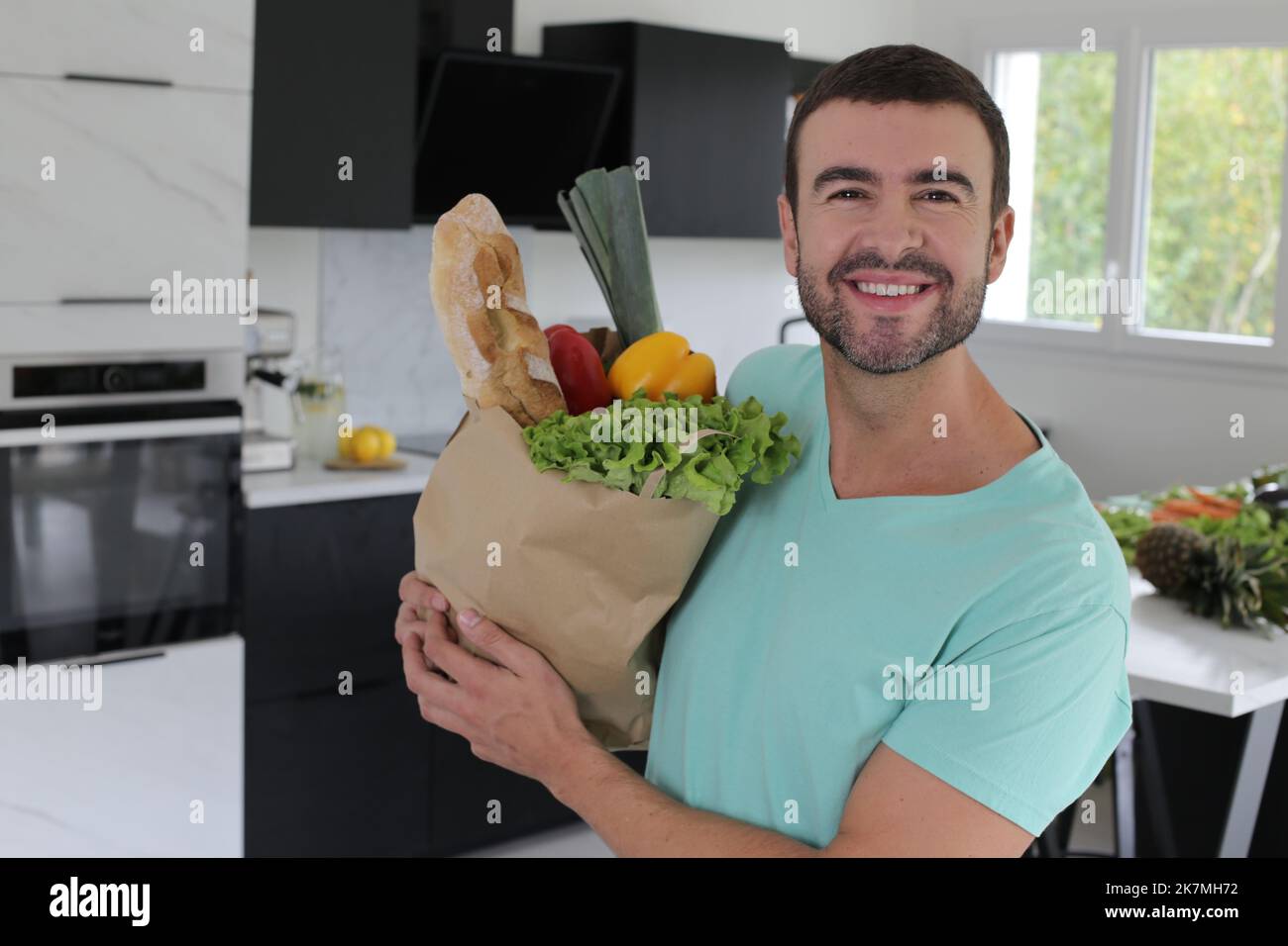 Un bel homme qui rentre à la maison après avoir fait ses courses Banque D'Images