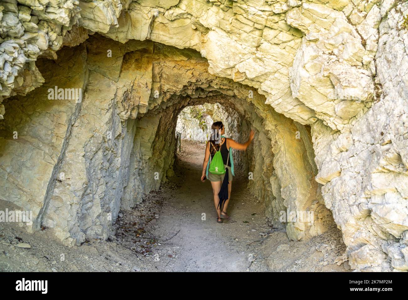 Frau im Felstunnel am Wanderweg rund um den Stausee Lac des Moron zwischen der Schweiz und Frankreich, Europa | Femme à l'intérieur du tunnel rocheux à la h Banque D'Images