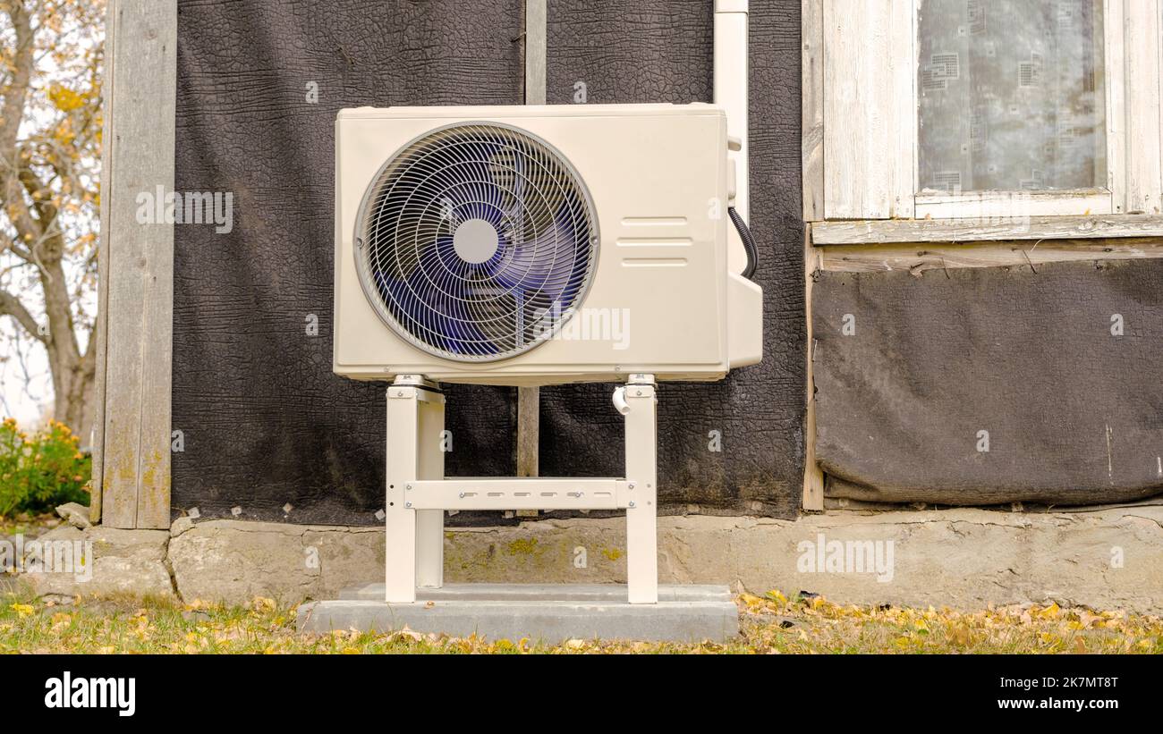 Une pompe à chaleur air-air est installée sur la façade extérieure de la vieille maison. Banque D'Images
