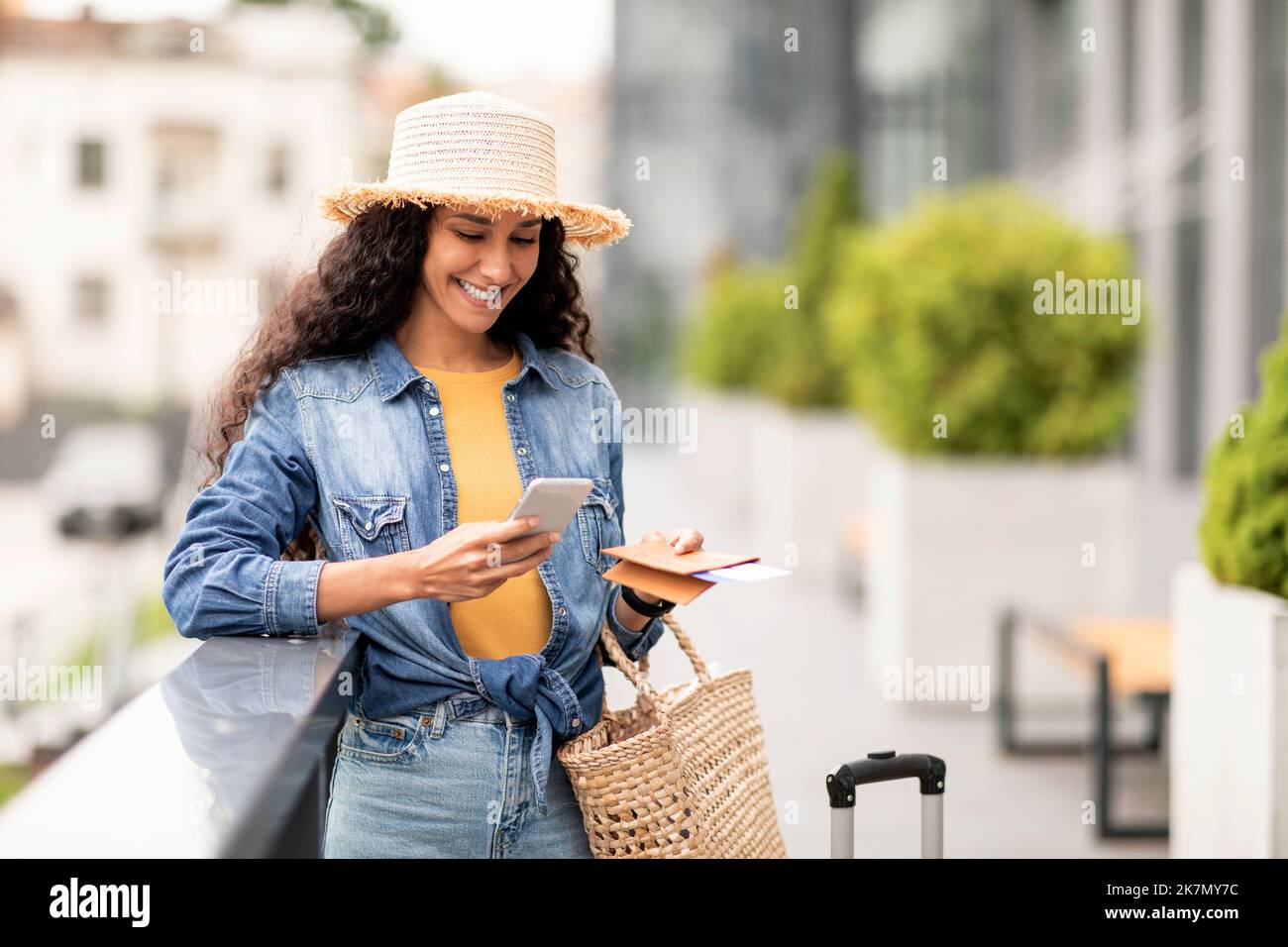 Jeune femme heureuse touriste debout près de l'aéroport, en utilisant le téléphone cellulaire Banque D'Images