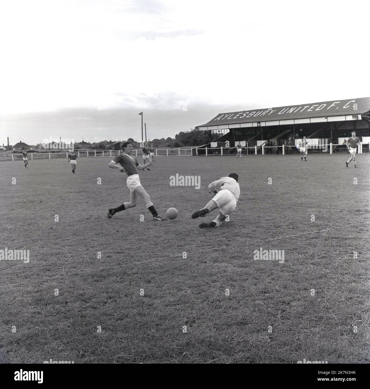 1964, historique, août, et les footballeurs participant à un essai d'avant-saison à Turnfurlong Lane, le terrain de football du FC Aylesbury United, gardien de but qui va faire une économie. Un club de football amateur à Buckinghamshire, Angleterre, Royaume-Uni, Aylesbury United a été formé en 1897 et son surnom est les Ducks. Banque D'Images