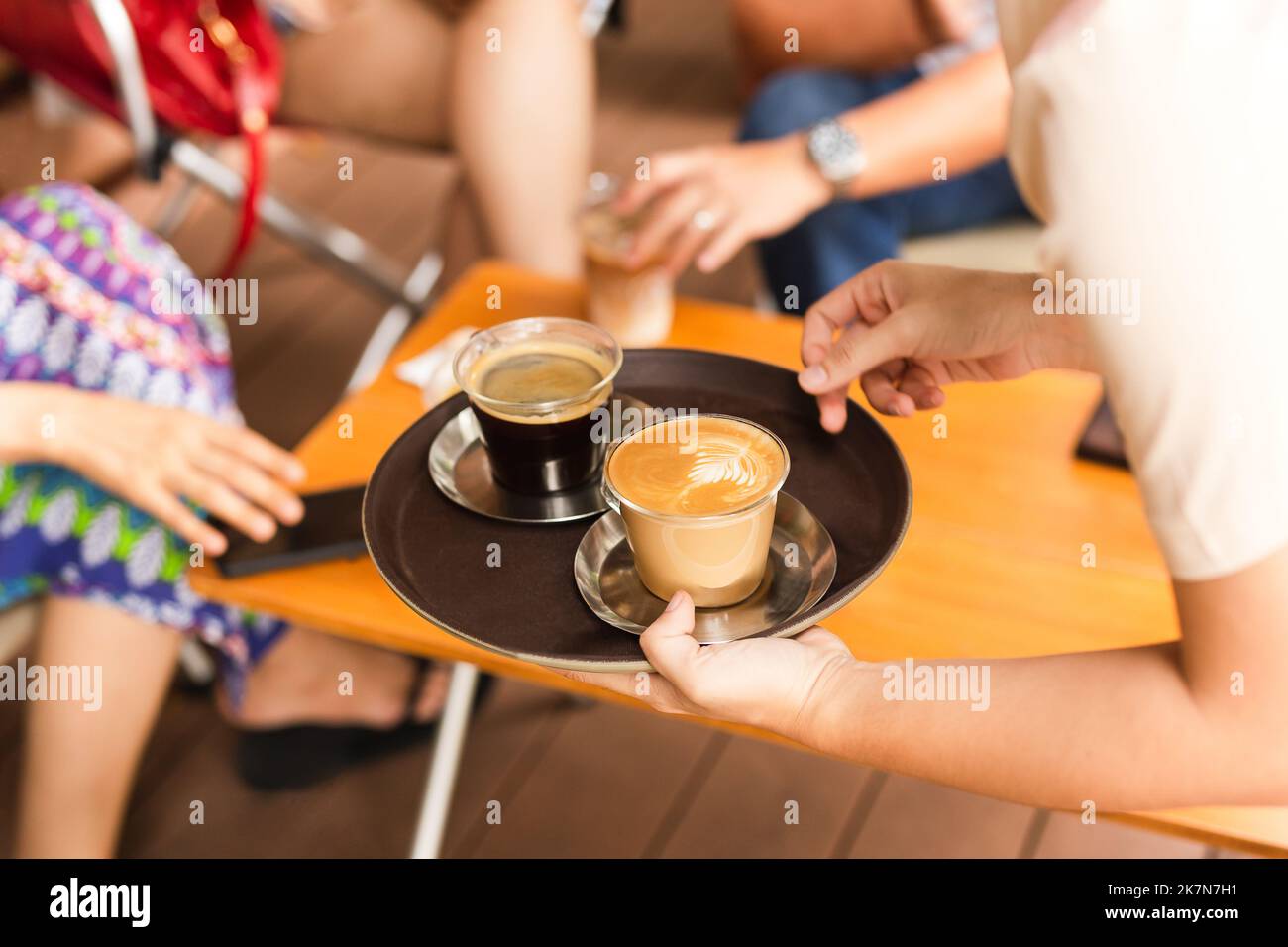 Serveuse servant un café chaud au café. Banque D'Images