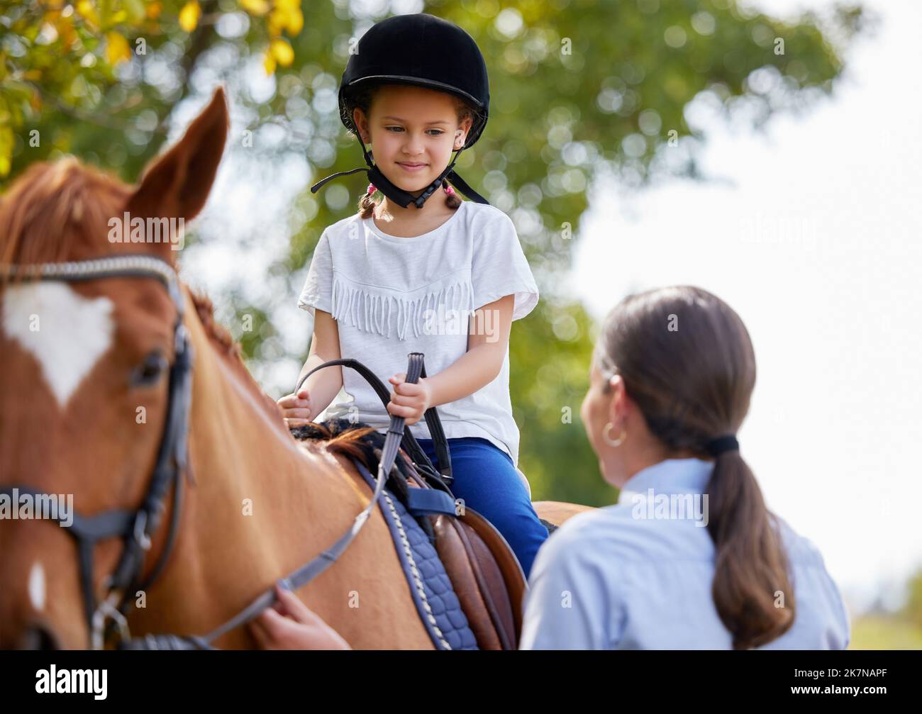 Aucune heure de vie n'est gaspillée qui est passée dans la selle. jeune fille avec son instructeur avec un cheval en plein air dans une forêt. Banque D'Images
