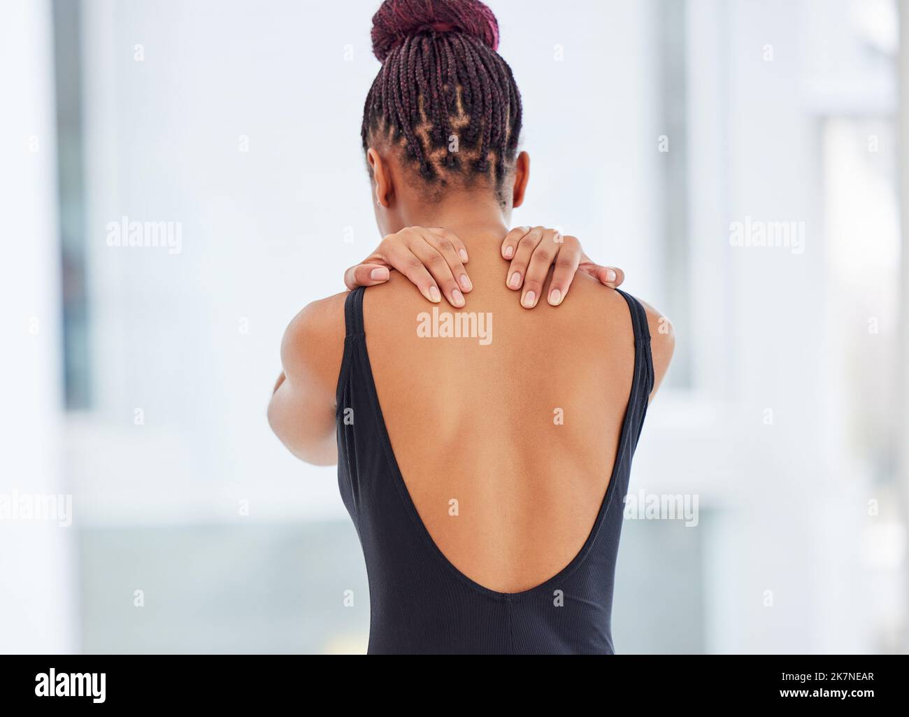 La douleur est dans mes épaules. une jeune ballerine souffrant de douleurs à l'épaule. Banque D'Images