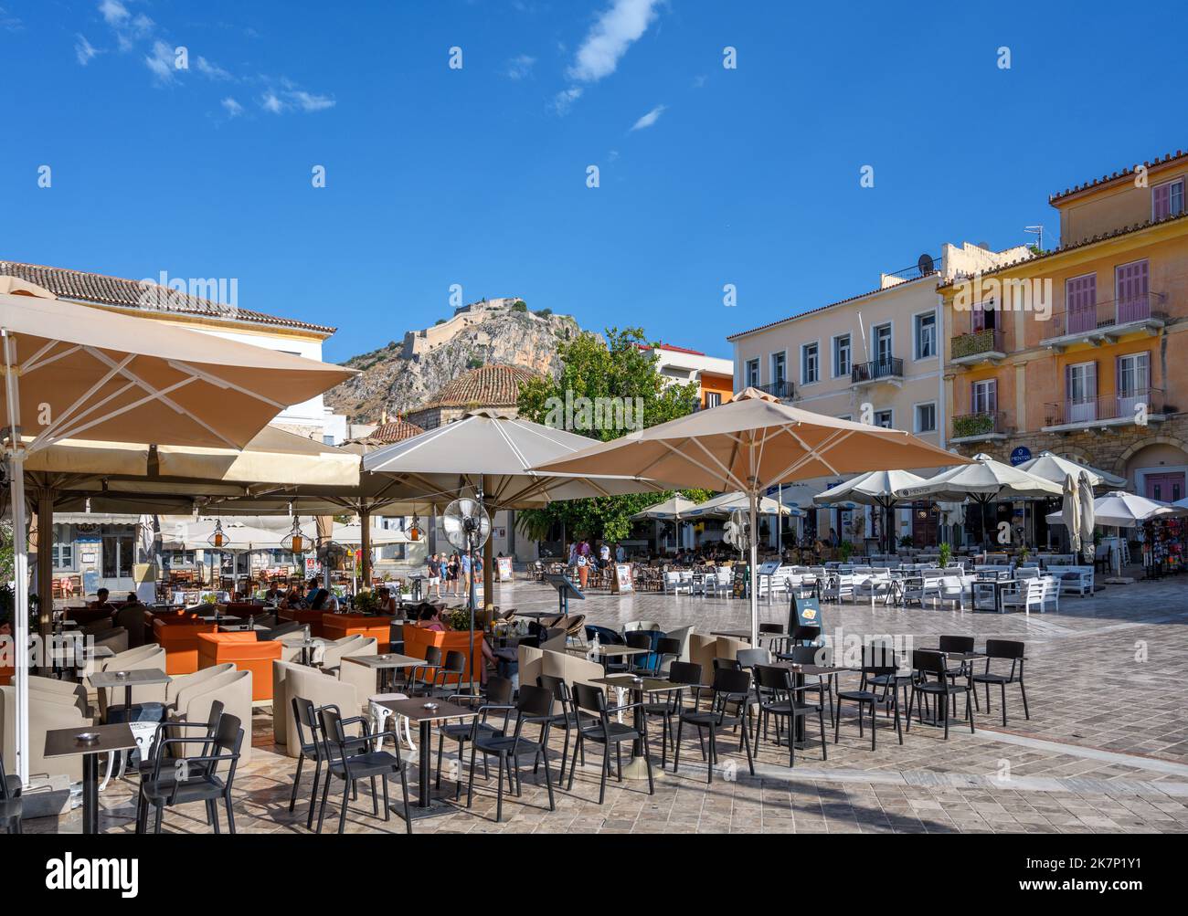 Cafés et restaurants sur la place Syntagma avec la forteresse de Palamidi derrière, Nafplio (Nafplion), Péloponnèse, Grèce Banque D'Images