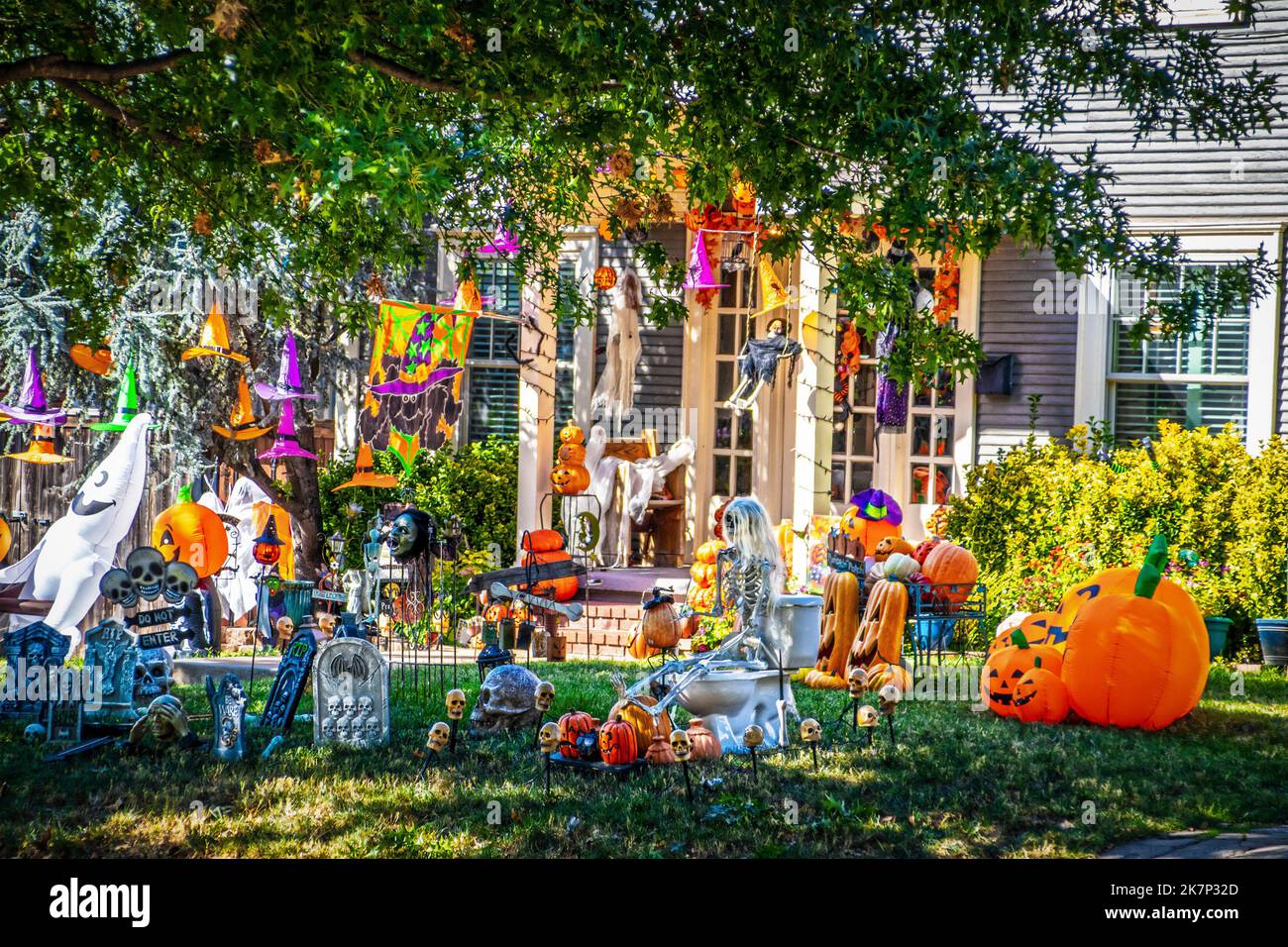 Trop Halloween - Maison avec cour remplie de décorations d'Halloween de chaque genre y compris le squelette sur siège de toilette et beaucoup de pierres tombales et petit moi Banque D'Images