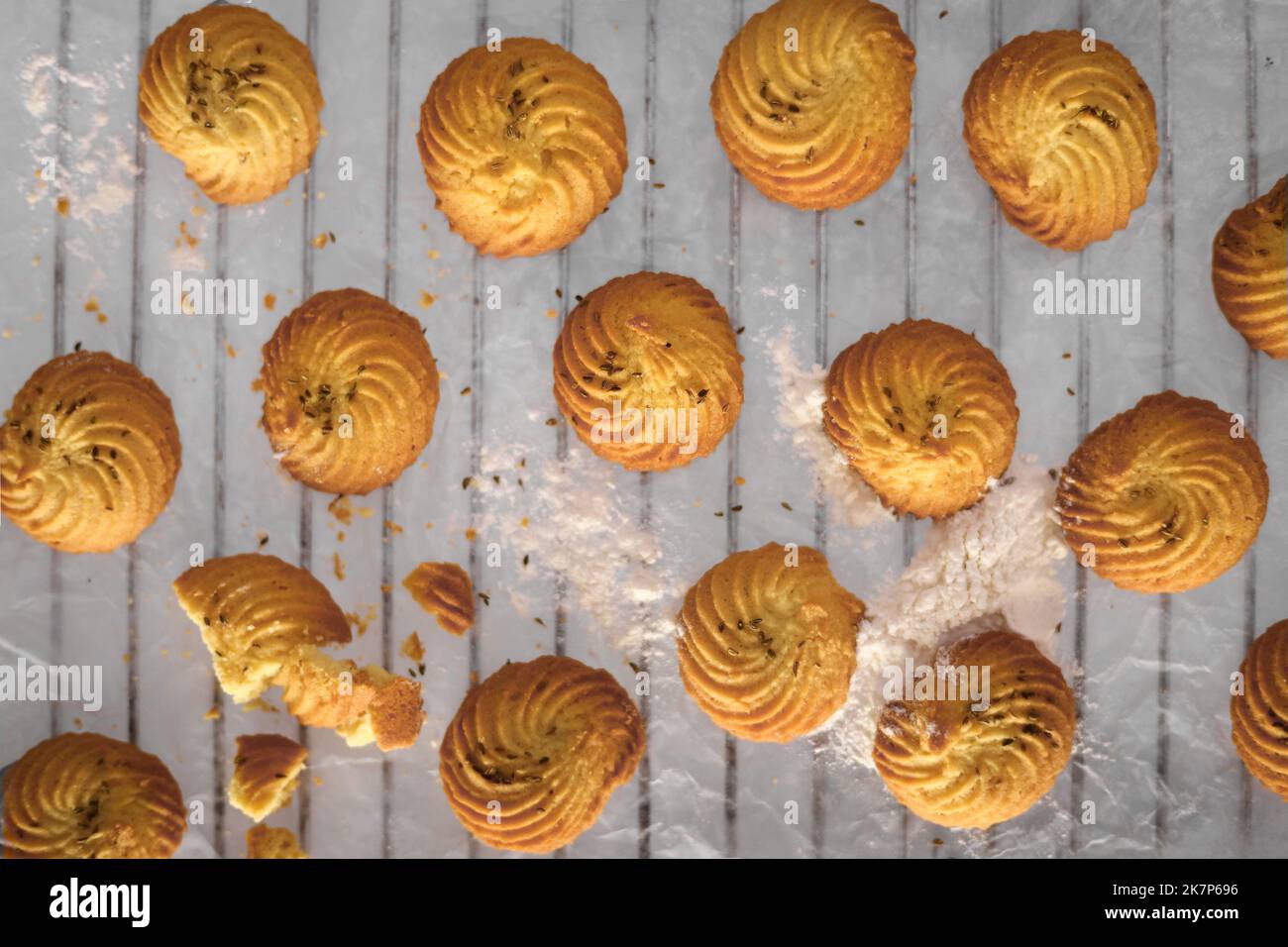 Petits gâteaux faits maison fraîchement cuits sur la grille du four sur fond sombre plat Banque D'Images