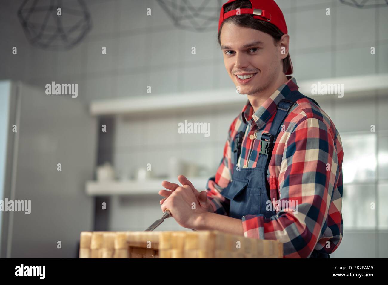 Joyeux ouvrier du bois appréciant le processus de fabrication d'une boîte en bois Banque D'Images