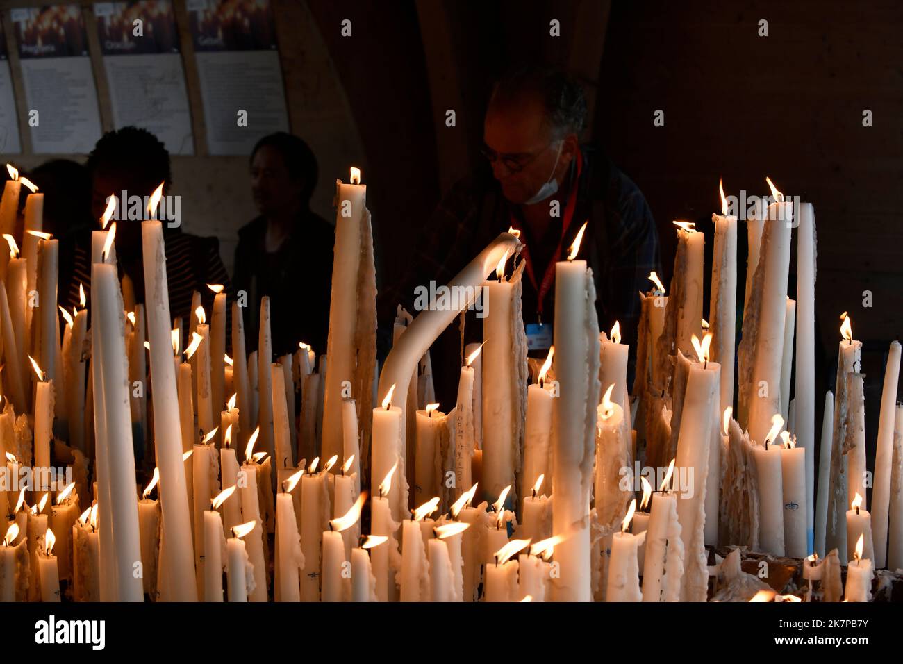 Lourdes, Hautes-Pyrénées, France. Les pèlerins chrétiens éclairent les bougies Banque D'Images
