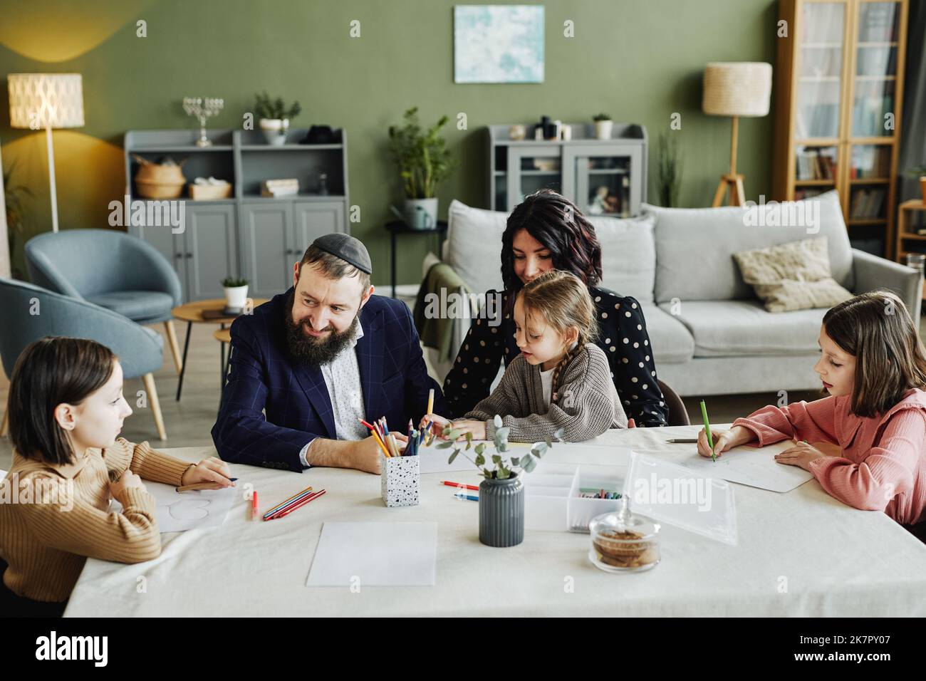 Portrait en grand angle de la famille juive moderne qui se dessine ensemble tout en étant assis à la table à la maison Banque D'Images