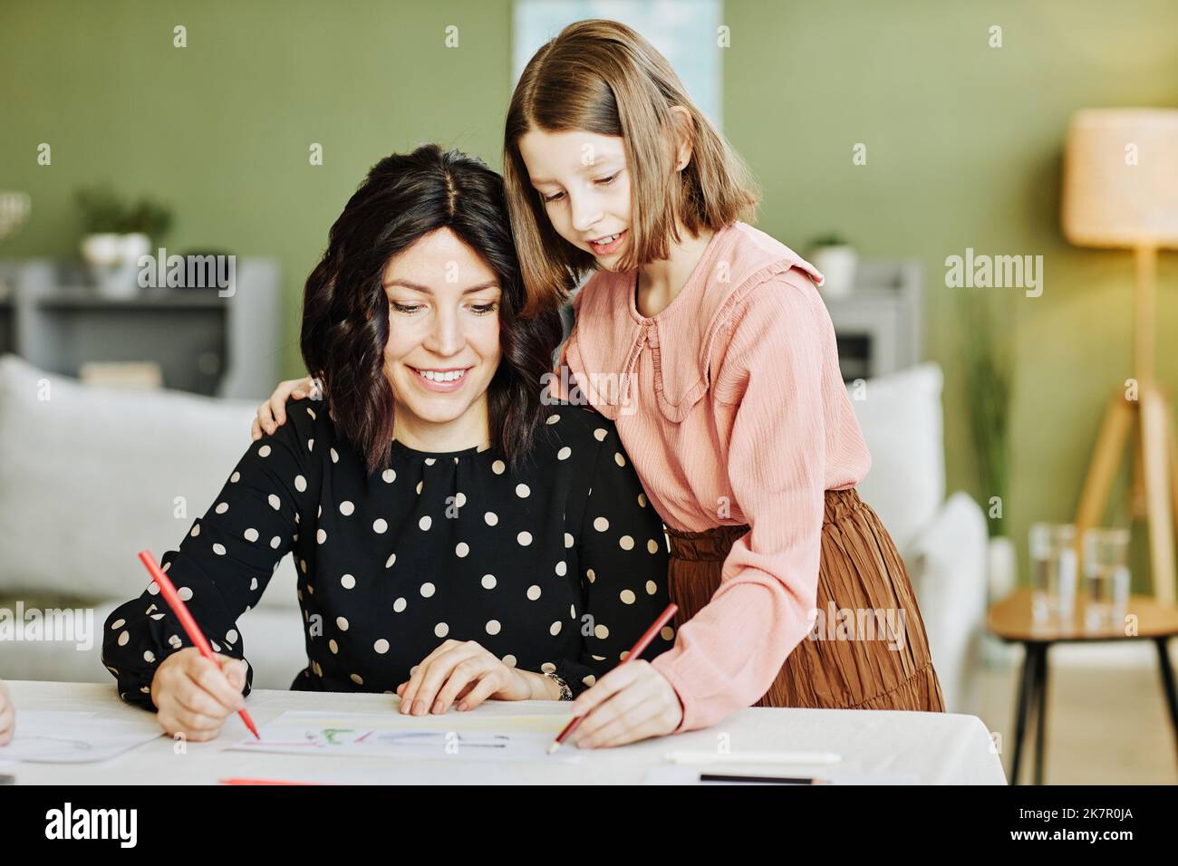 Portrait d'une mère heureuse et d'une fille qui dessinant des photos ensemble dans le cadre de la maison Banque D'Images