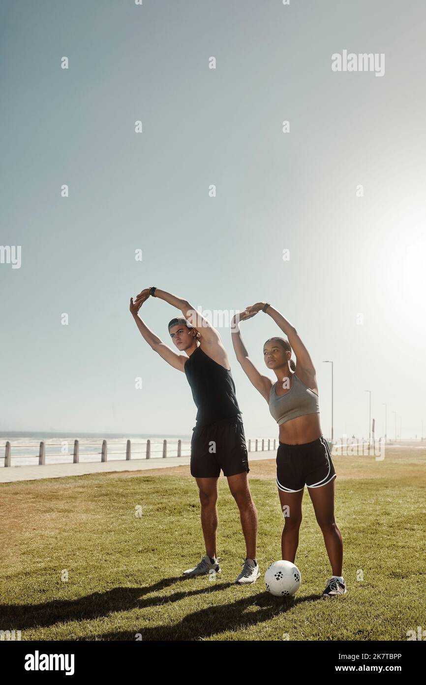 Fitness, parc de plage et couple faisant un exercice d'étirement comme un échauffement pour l'entraînement de football. Sports, athlètes et homme et femme en bonne santé Banque D'Images