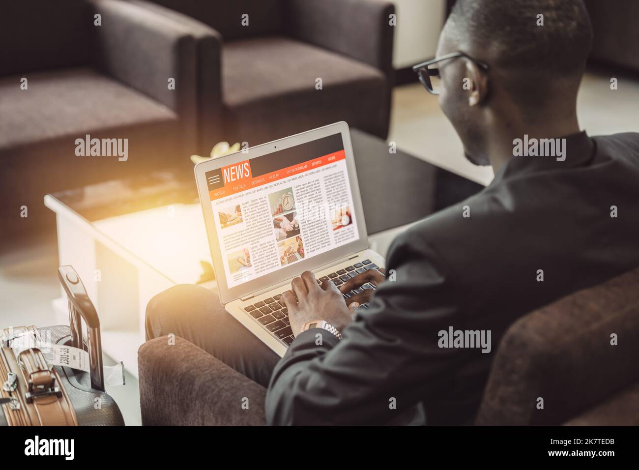 homme d'affaires lisant le site de mise à jour des nouvelles sur ordinateur portable pendant l'attente de voyage dans le salon de l'aéroport Banque D'Images