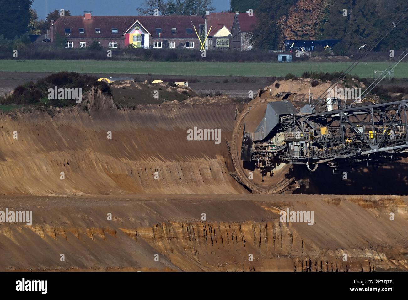 19 octobre 2022, Rhénanie-du-Nord-Westphalie, Jüchen: Une pelle hydraulique à roue à godets travaille dans la mine de lignite à ciel ouvert Garzweiler. Le village de Lützerath est visible en arrière-plan. L'élimination du charbon dans le champ de houille de Rhenish en Rhénanie-du-Nord-Westphalie doit être avancée de huit ans à 2030. Face à la crise énergétique actuelle, deux centrales électriques au lignite doivent fonctionner plus longtemps que prévu. Photo: Federico Gambarini/dpa Banque D'Images