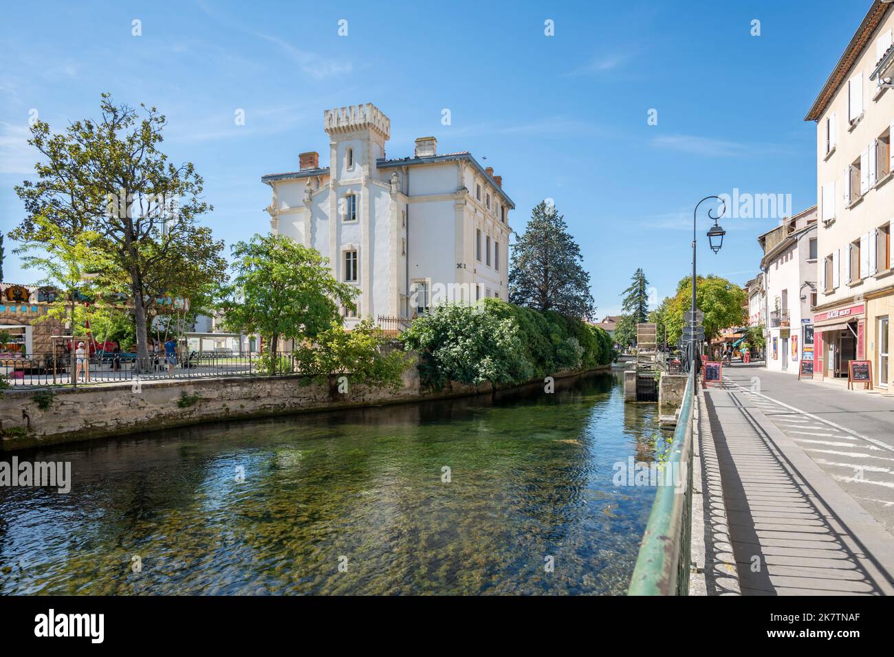 Ancien bâtiment de l'Isle-sur-la-Sorgue avec canal d'eau en été et espace copie. France Banque D'Images