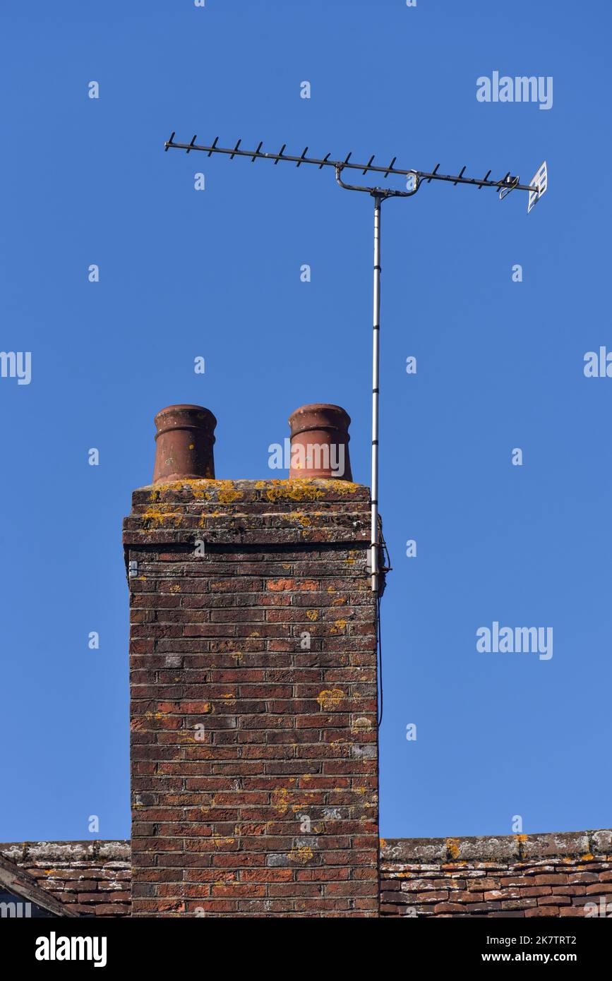 Cheminée en brique de style ancien avec pot en céramique sur le dessus dans un village rural dans le Hampshire, Angleterre. Banque D'Images