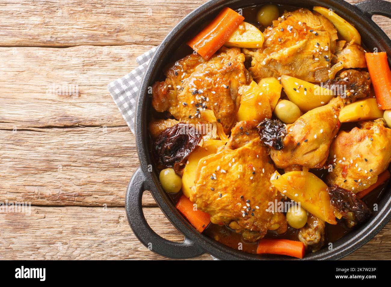 Ragoût gallo en chicha avec poulet, pruneaux, légumes et épices cuits pour avoir une saveur et un arôme merveilleux sur la poêle sur la table en bois. Banque D'Images