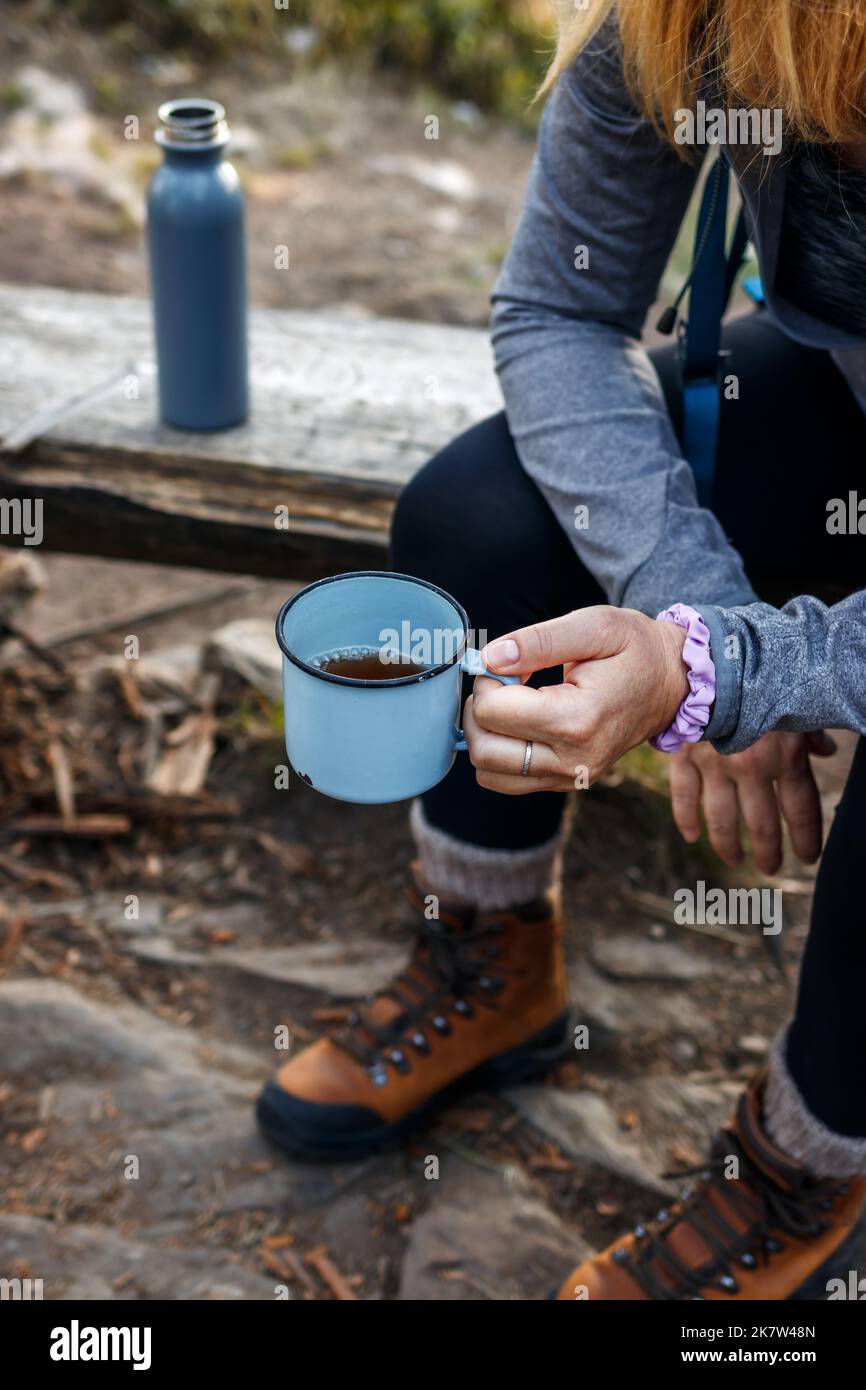 Femme randonneur prenant une pause avec une boisson chaude pendant le trekking de montagne. Rafraîchissement avec une tasse de thé Banque D'Images