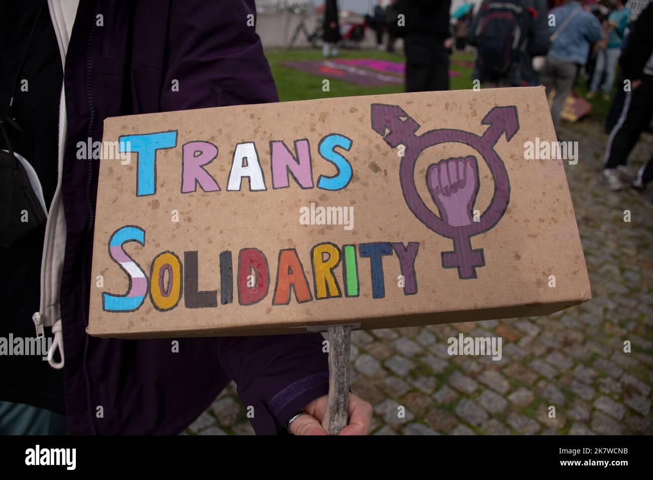 Un manifestant contre les droits transgenres affiche un signe de solidarité trans lors d'une manifestation contre Terfs à Berlin, en Allemagne Banque D'Images