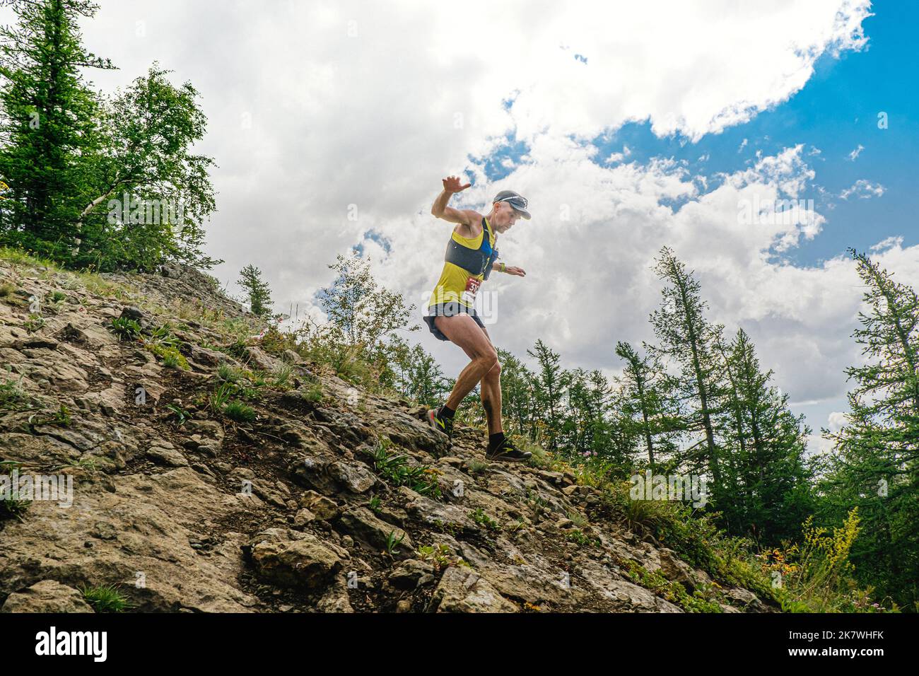 Bannoe, Russie - 31 juillet 2022 : un coureur de sexe masculin part en descente de montagne abrupte sur le sentier sauvage de MMK Banque D'Images Bannoe, Russie - 31 juillet 2022 : un coureur de sexe masculin part en descente de montagne abrupte sur le sentier sauvage de MMK Banque D'Images