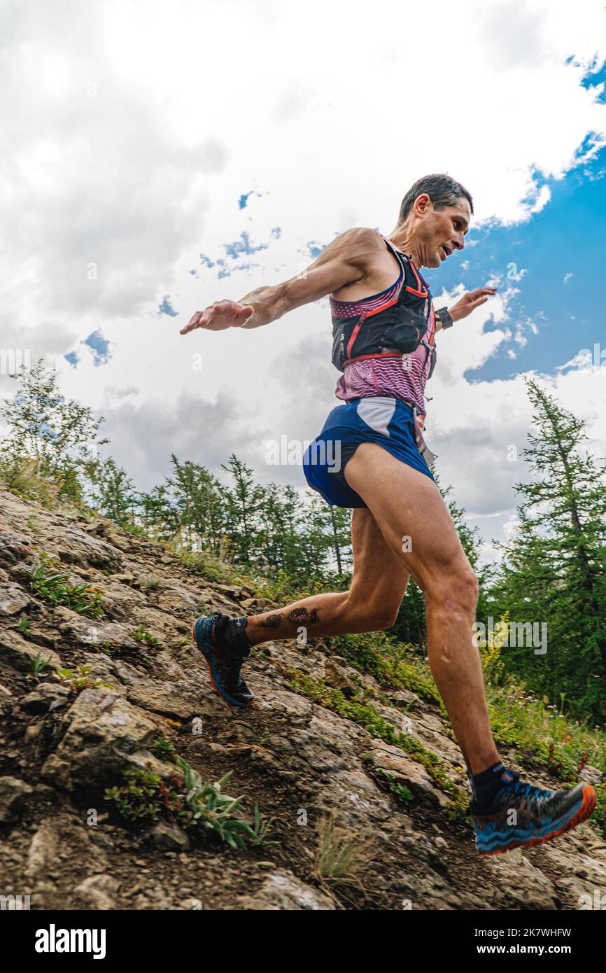 Bannoe, Russie - 31 juillet 2022: Athlète coureur courir la descente de montagne abrupte dans le sentier sauvage de MMK Banque D'Images