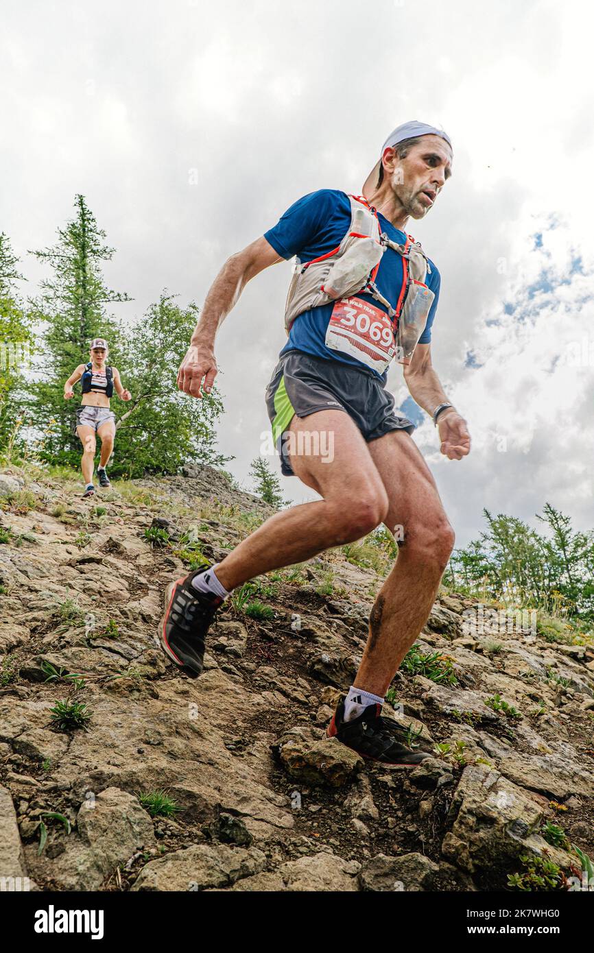 Bannoe, Russie - 31 juillet 2022: L'homme et la femme coureuse courent une descente de montagne abrupte dans le sentier sauvage de MMK Banque D'Images Bannoe, Russie - 31 juillet 2022: L'homme et la femme coureuse courent une descente de montagne abrupte dans le sentier sauvage de MMK Banque D'Images