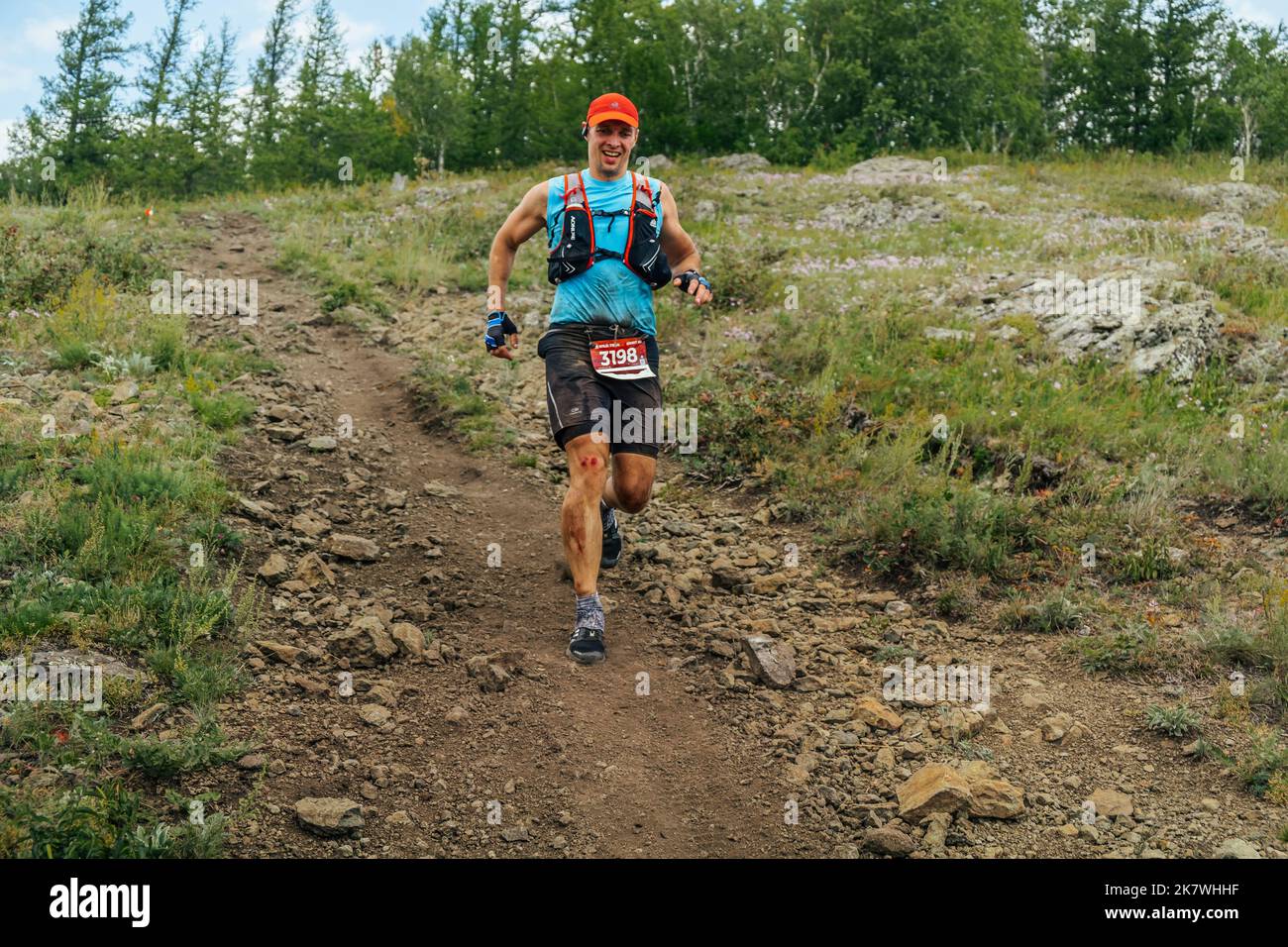 Bannoe, Russie - 31 juillet 2022: Athlète coureur avec blessure sanglante au genou piste de course dans le MMK Wild Trail Banque D'Images Bannoe, Russie - 31 juillet 2022: Athlète coureur avec blessure sanglante au genou piste de course dans le MMK Wild Trail Banque D'Images