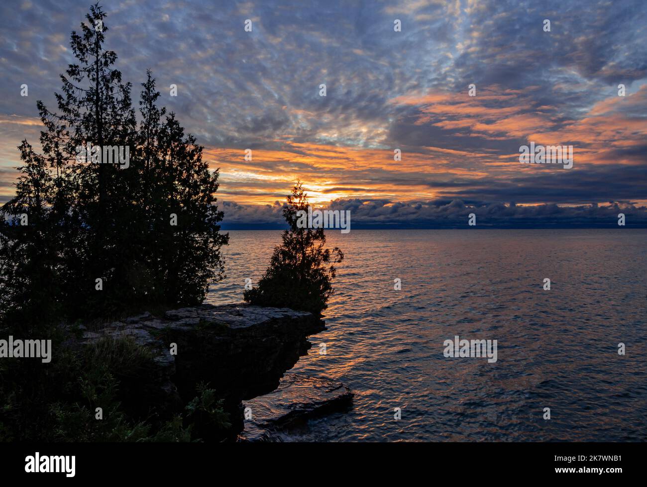 Le soleil levant éclaire le dessous des nuages sur un matin vif d'octobre au-dessus du lac Michigan, du parc du comté de Cave point, du comté de Door, Wisconsin Banque D'Images