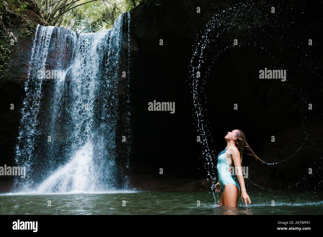 Femme s'amuser dans la piscine naturelle sous les chutes d'eau de Suwat cascade dans la jungle tropicale. Excursion d'une journée dans la nature, activités de randonnée, aventure et divertissement Banque D'Images