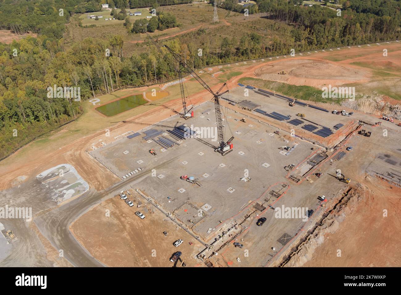 Vue aérienne des grues de grande hauteur travaillant sur le chantier de construction d'un bâtiment de grande hauteur Banque D'Images