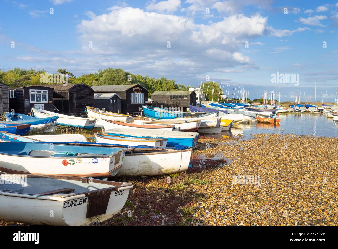 Des bateaux amarrés devant les cabanes de pêcheurs et le salon de la rivière Riverside sur la plage de galets de la rivière ADLE à Orford Suffolk Angleterre Royaume-Uni Europe Banque D'Images