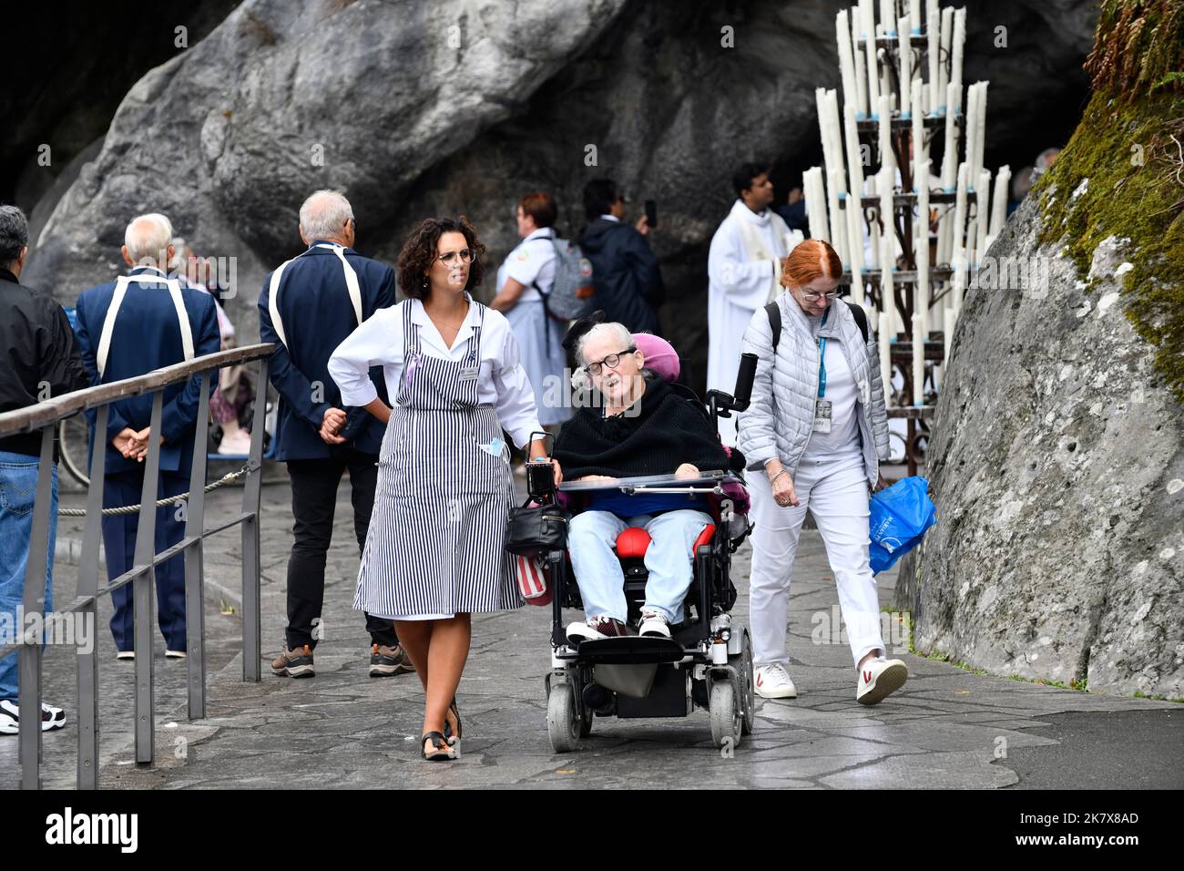 Lourdes, Hautes-Pyrénées, France. Soignant en fauteuil roulant avec pèlerin Banque D'Images