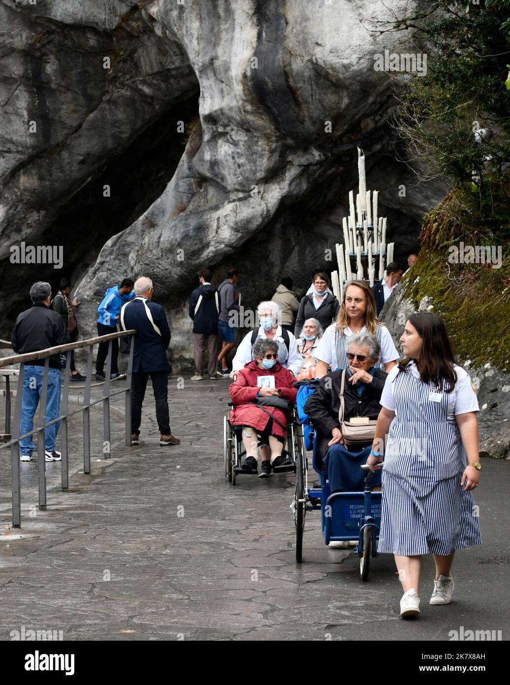 Lourdes, Hautes-Pyrénées, France. Soignants avec pèlerins en fauteuil roulant Banque D'Images