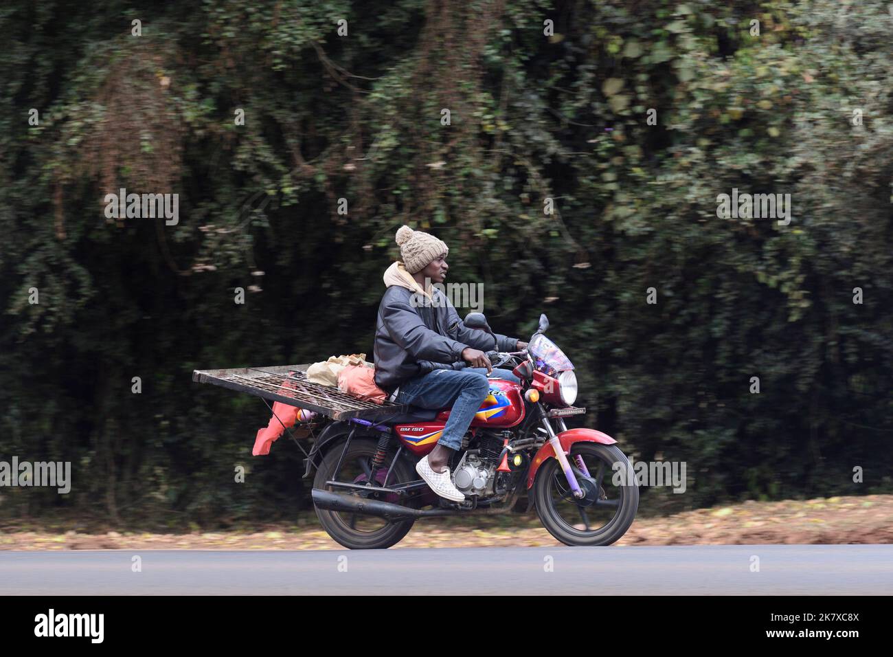 Un taxi moto, connu sous le nom de Boda boda, en Afrique de l'est, transportant un cadre de lit. Boda bodas sont une partie importante du réseau de transport, étant utilisé t Banque D'Images